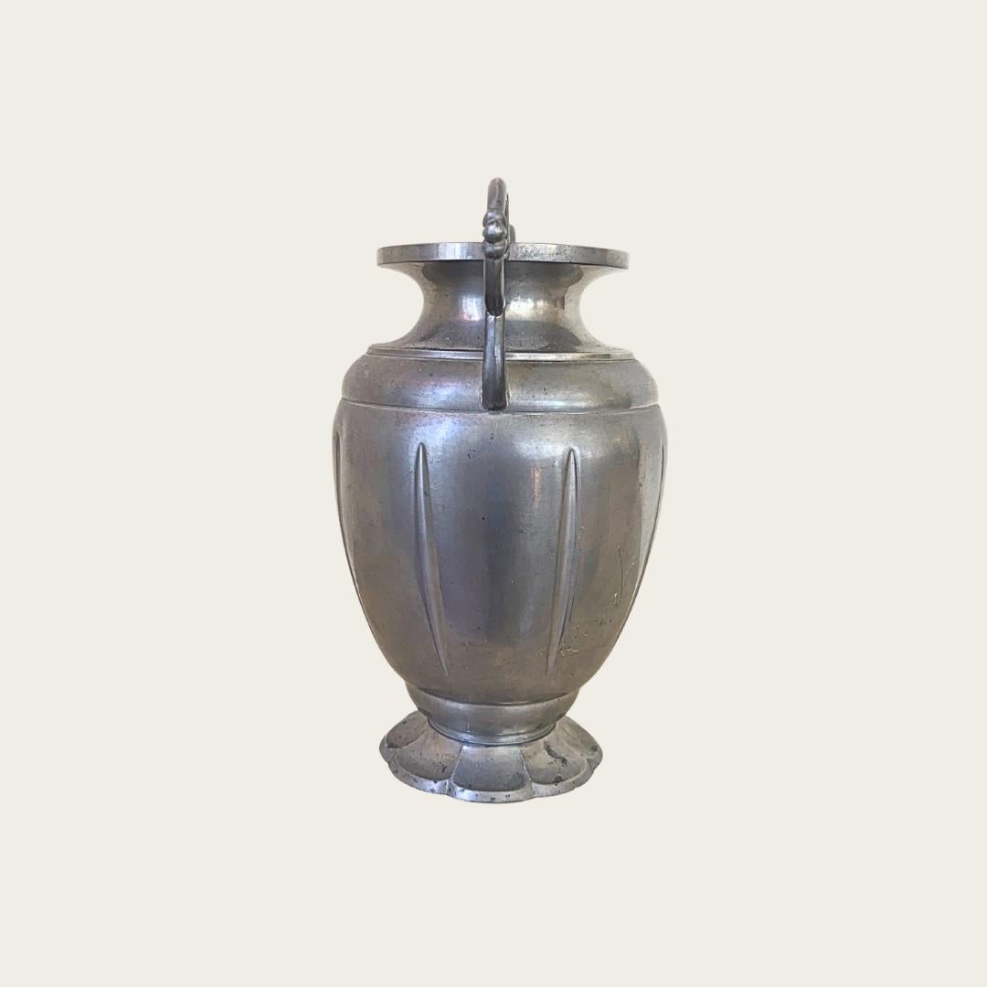 1940s, Sweden. This Swedish Grace vessel features decorative handles and a faceted base. It shows minor scattered dents on the side consistent with its age. The price reflects these condition details.