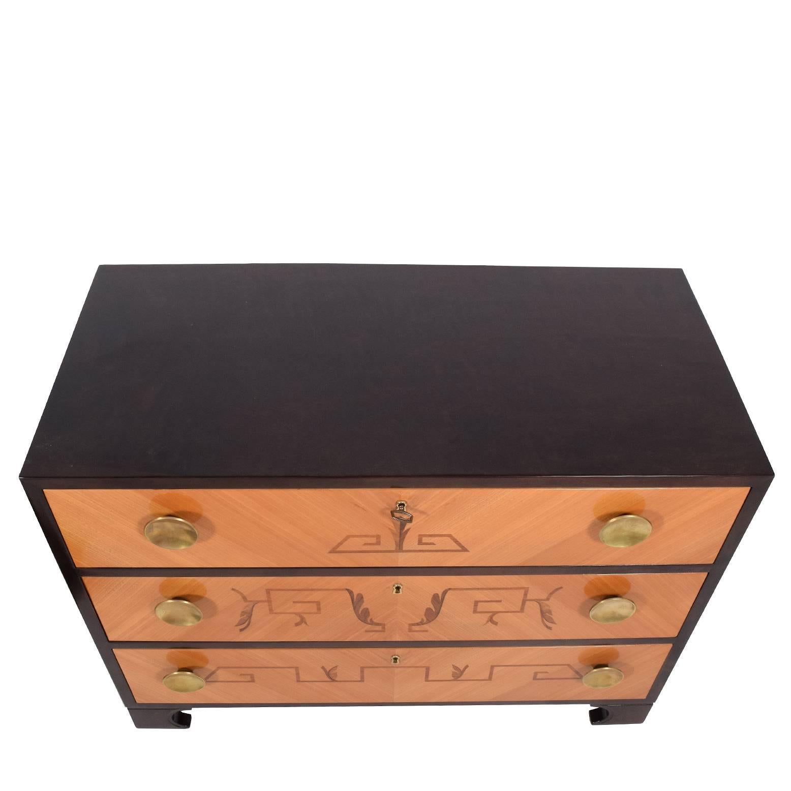 Features three drawers with Art Deco inlay designs and solid brass pulls.