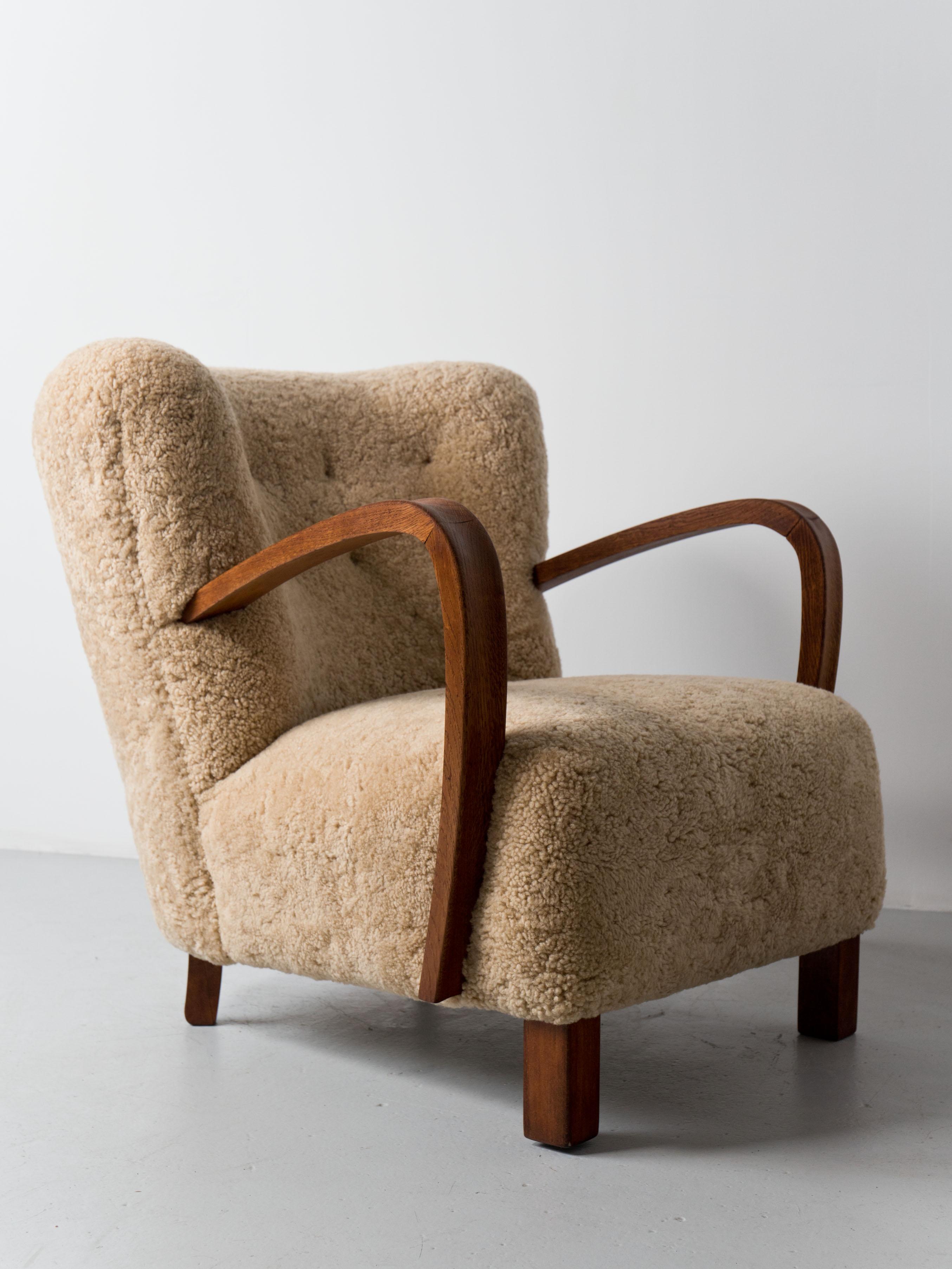 Swedish lounge chair, circa 1940s with curved back and exposed oak arms, newly upholstered in shearling hides with leather button detail.
Great craftsmanship and construction.



   