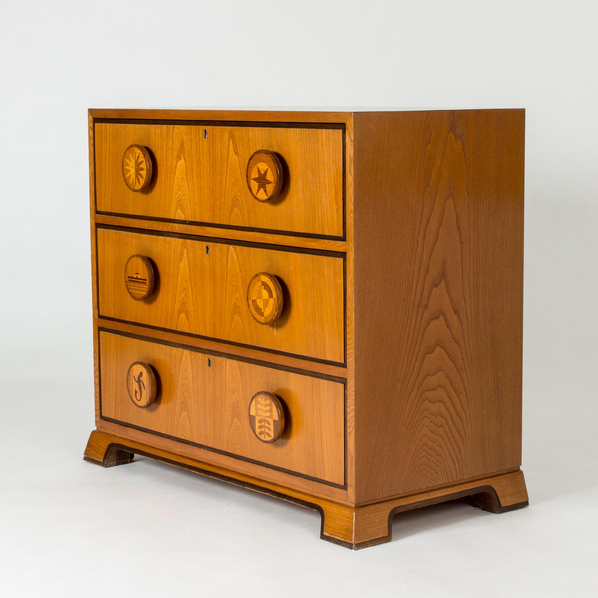 Chest of drawers by Otto Schulz for Boet. Amazing Swedish Modern chest of drawers, made from mahogany. Oversized round drawer handles with inlayed decor of different images. They show a sun, a star, a boat on the water, a compass, a lizard and