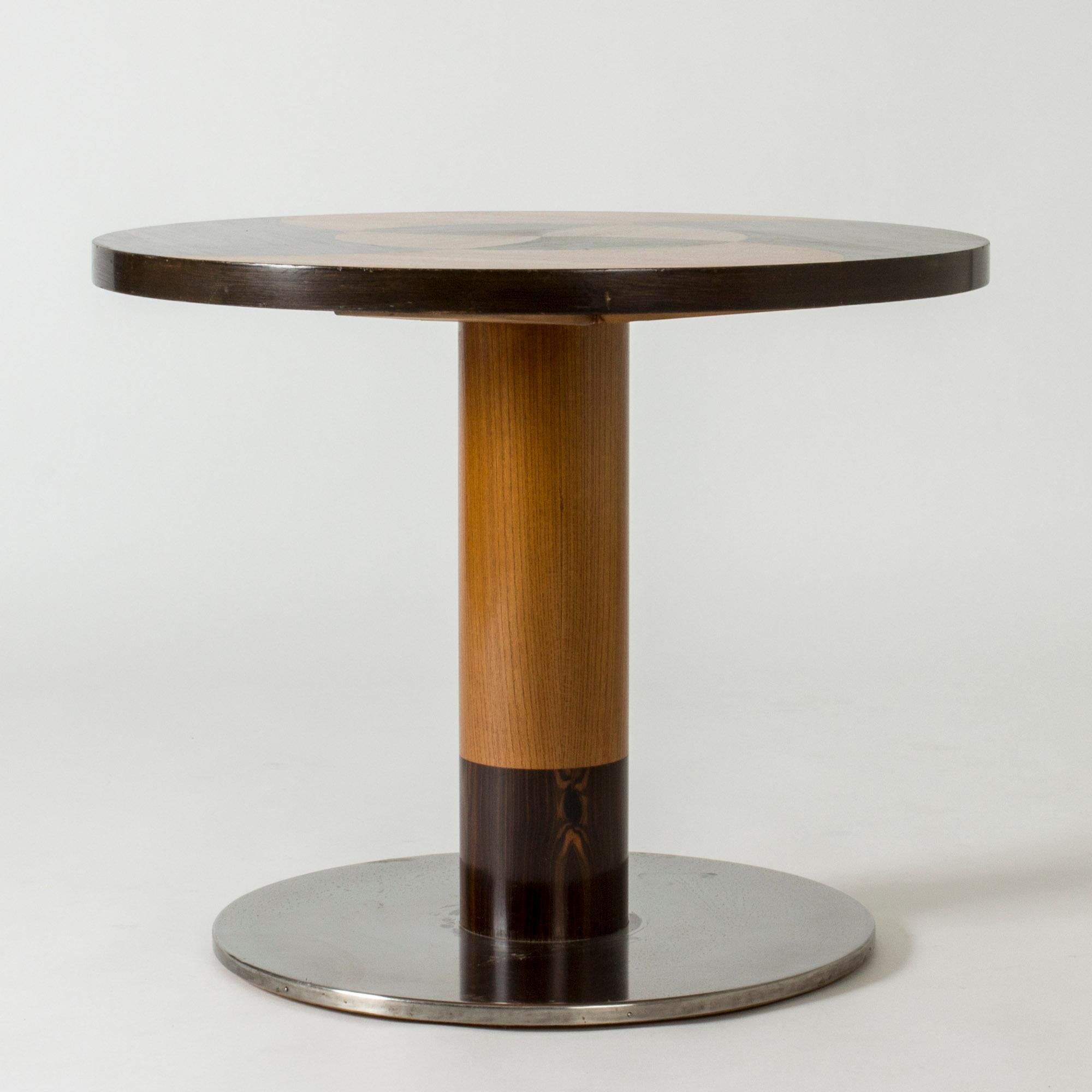Coffee or occasional table by Otto Schulz, in a sleek round form. Made from wood with a steel base. Striking graphic inlays in different colored wood.