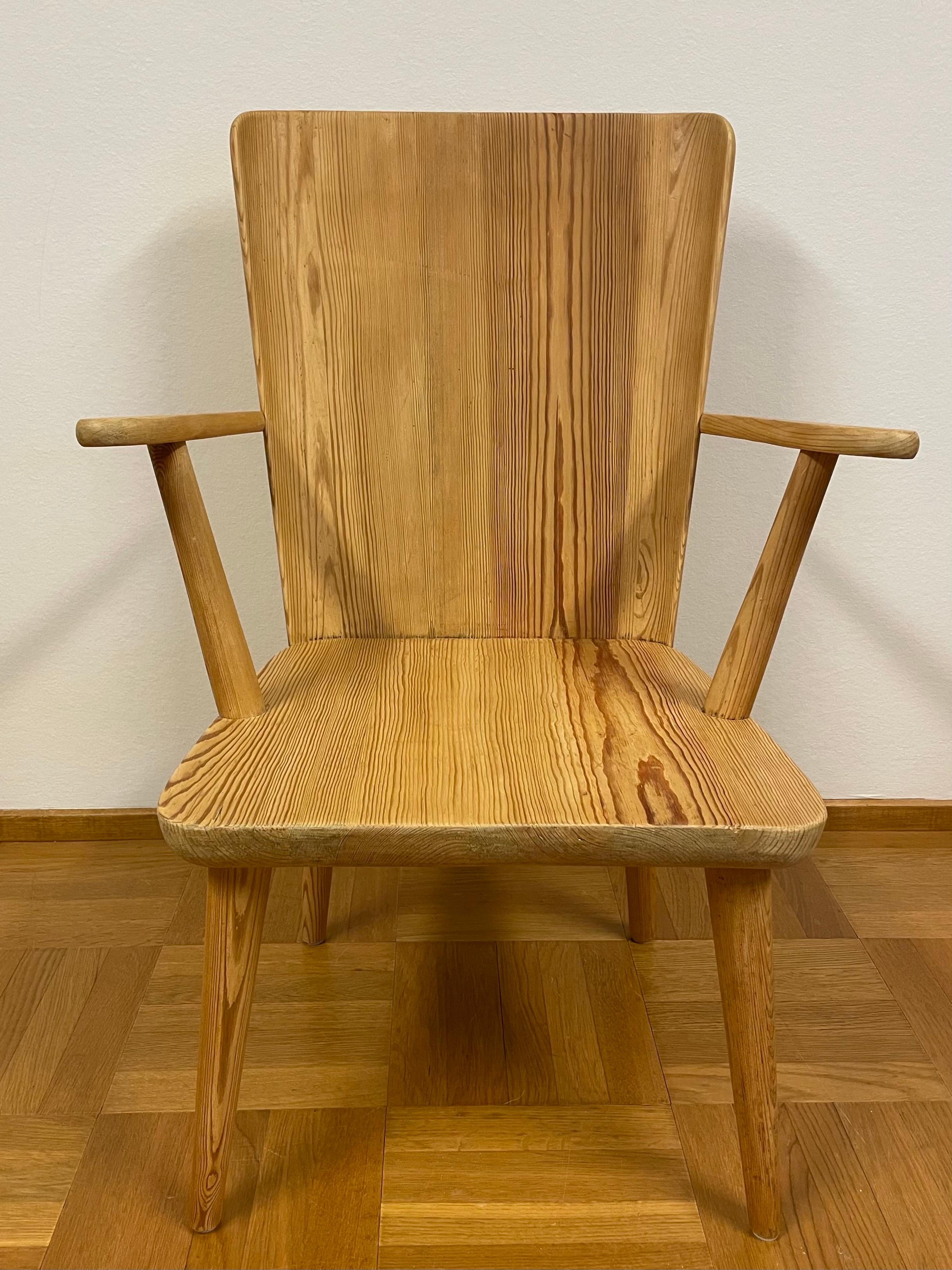 This is the Swedish pine armchair designed by Göran Malmvall for his own furniture company Karl Andersson & Söner. 
Probably an early copy from the 1940s. 
A beautiful patinated solid pine armchair with a high back with slightly curved sides. 

This