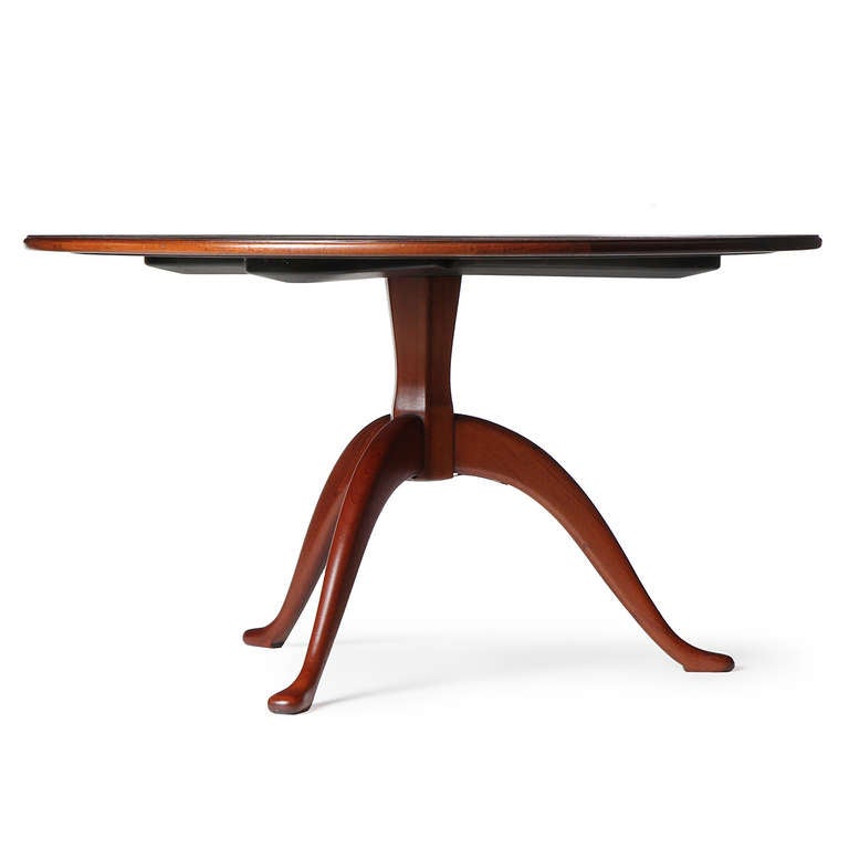 A remarkable and elegant Cuban mahogany round center table with a sculpted tripod base.