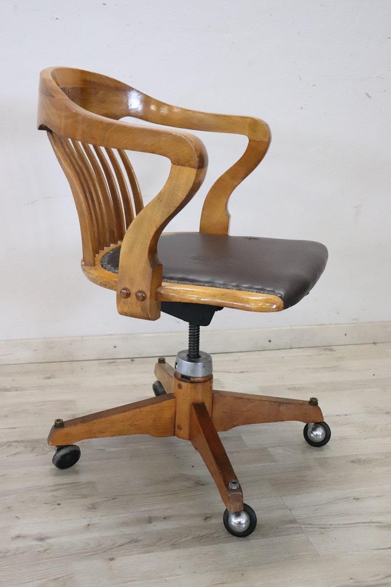 Swivel desk chair in solid oak wood, Italy 1940s. Wide and comfortable seat with enveloping backrest. The chair can also be adjusted in height. Equipped with wheels for practical movement. Signs of wear on the imitation leather, replacement is