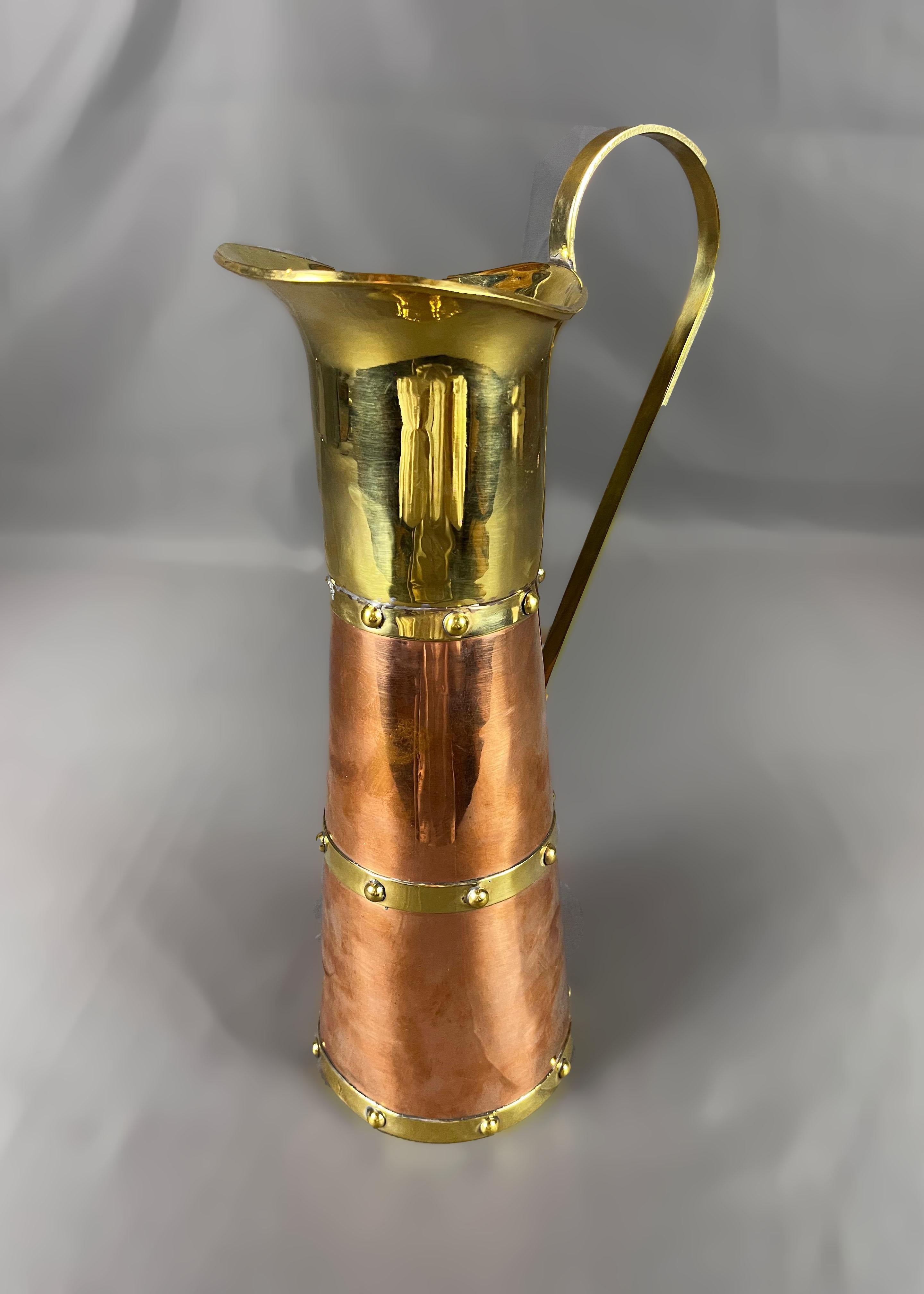 A rare 1940's Taxco Mexico copper and brass pitcher by Mexican silversmith and metalworker Héctor Aguilar. The pitcher combines the use of brass and copper joined by round brass rivets. The piece is sealed on the bottom with the HA monogram, the