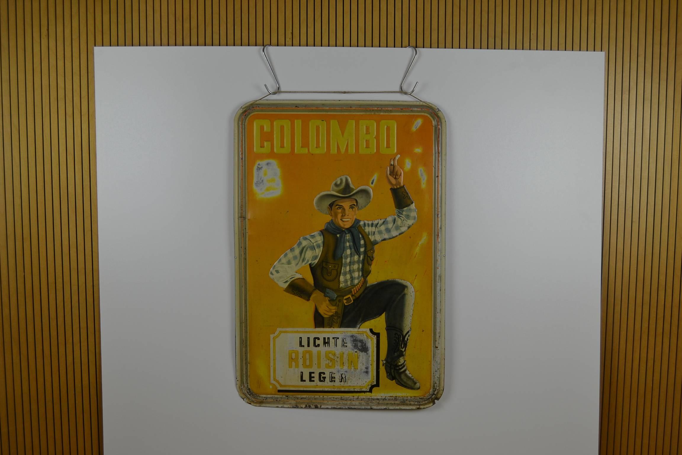 Very rare Large original Tin Advertising Sign  
for Colombo Cigarettes - Colombo Smokes - Colombo Tobacco . 
This Publicity Sign has an awesome design: a smoking Cowboy dressed in Cowboy clothes , Cowboy hat, belt with gun and cowboy boots.

This