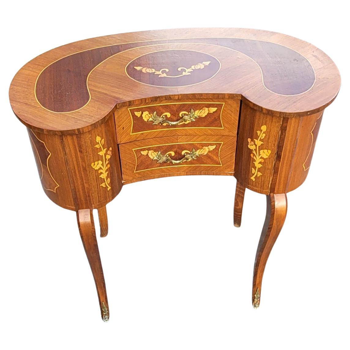 A gorgeous 1940s French Two-Drawer Continental Marquetry Mahogany kidney dressing table in great vintage condition. Features amazing symmetrical marquetry works, two drawers with original pulls and ormolu mounted front legs. Measures 26