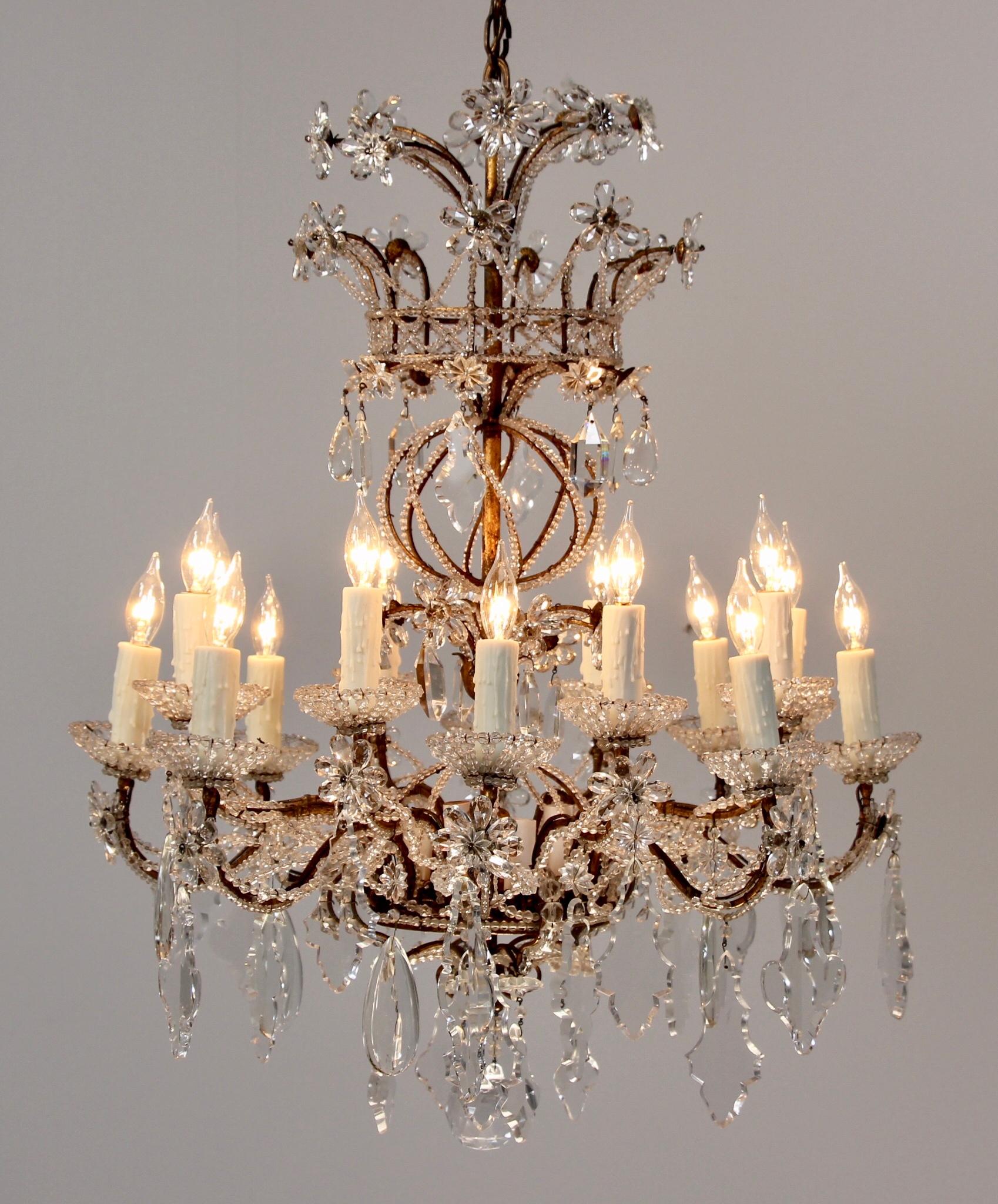 Spectacular, 1940s Venetian gilt iron and crystal beaded chandelier in the Louis XVI style. This rare beauty features an elaborate gilded iron frame which has been intricately beaded and decorated with an assortment of French pendalogues. Note the