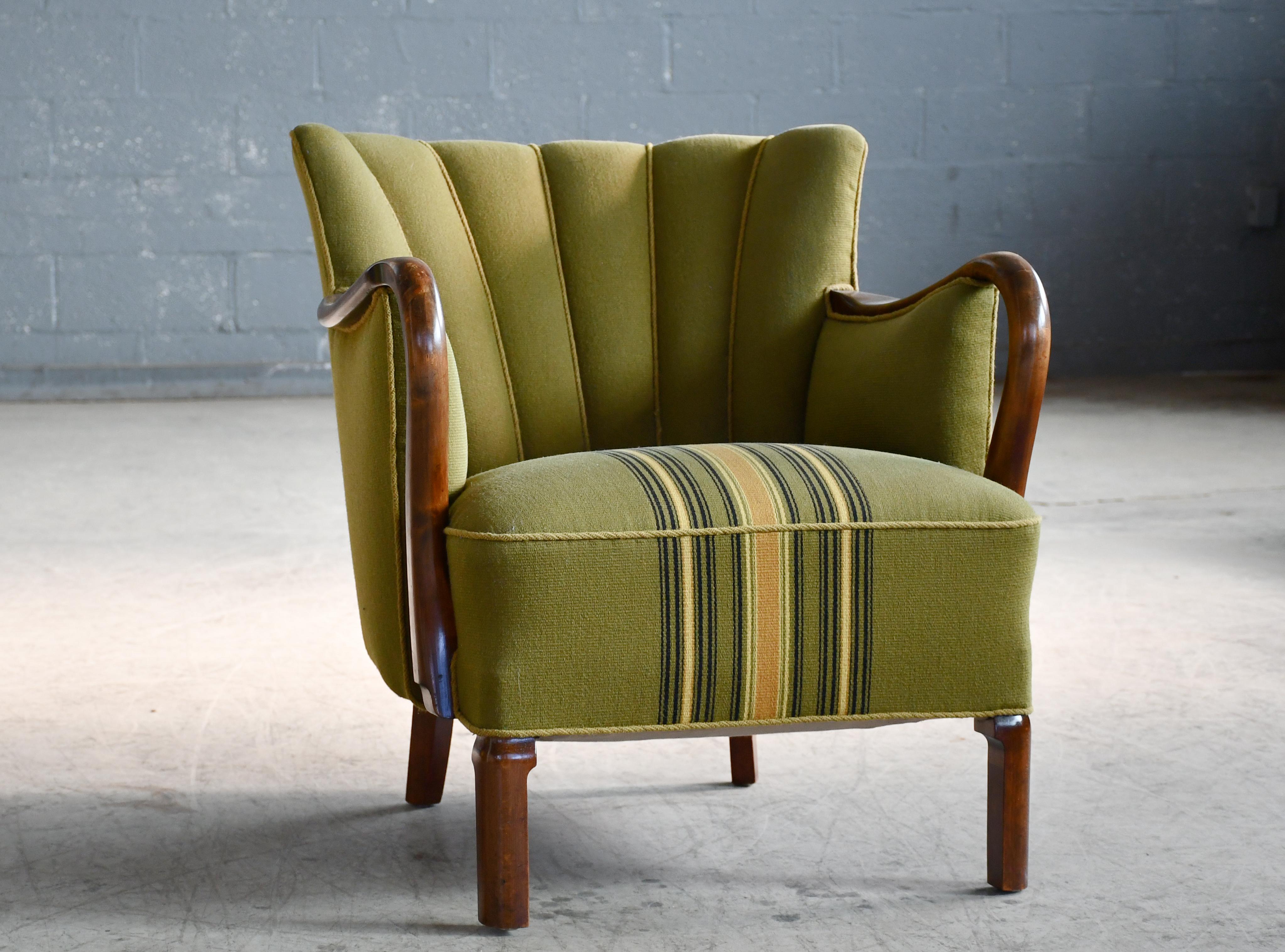 Superb Danish late Art Deco early midcentury chair from the early 1930's with spring cushions and beautiful open armrests and legs carved in solid stained Cuban Mahogany with great color and patina. Typical of Viggo Boesen's design for Slagelse