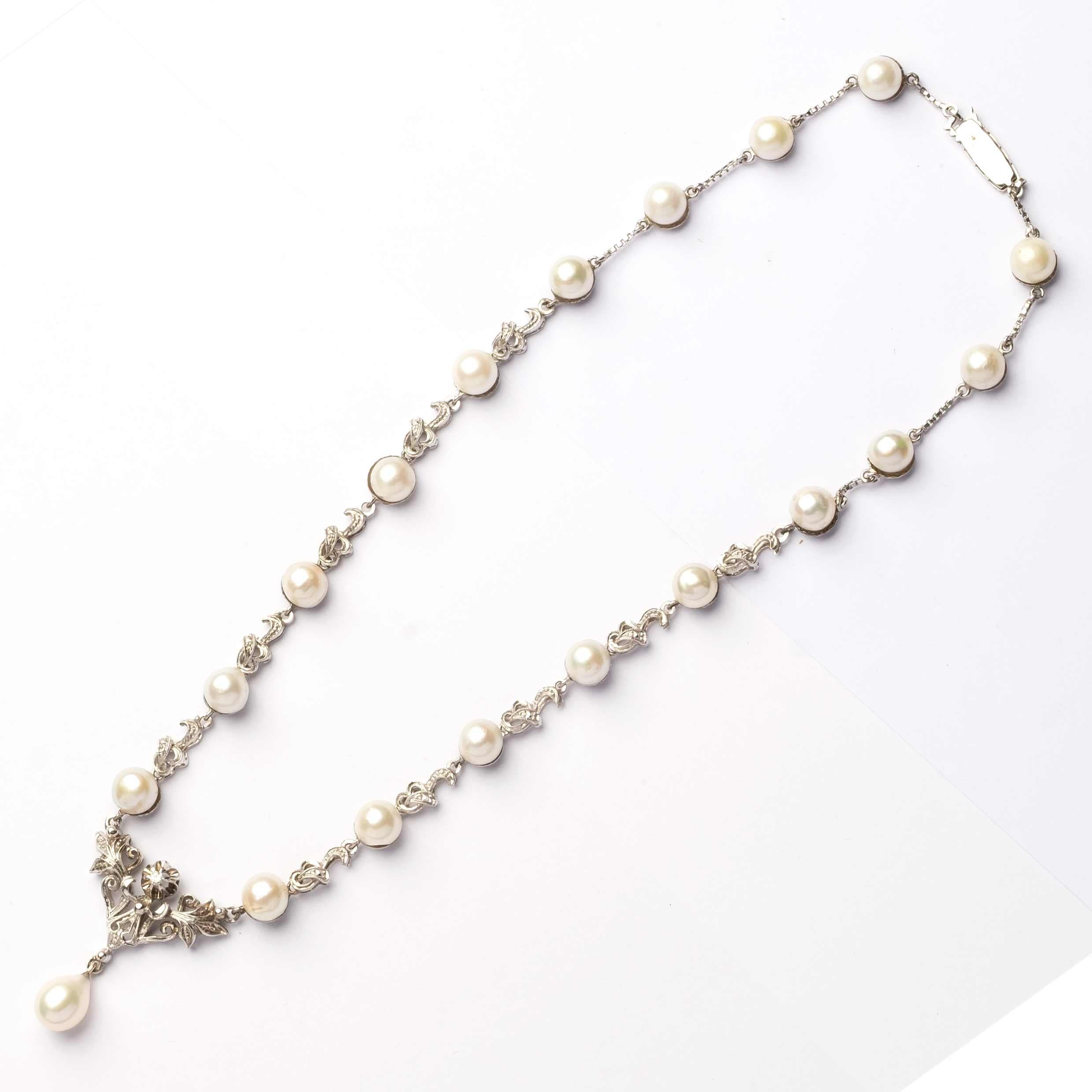 Raffinata collana vintage degli anni '40 realizzata in oro bianco 18 ct, finemente dettagliata e impreziosita da perle coltivate giapponesi di circa 7 mm. Al centro, un piccolo diamante da 0,05 carati aggiunge un delicato scintillio ed eleganza. Un