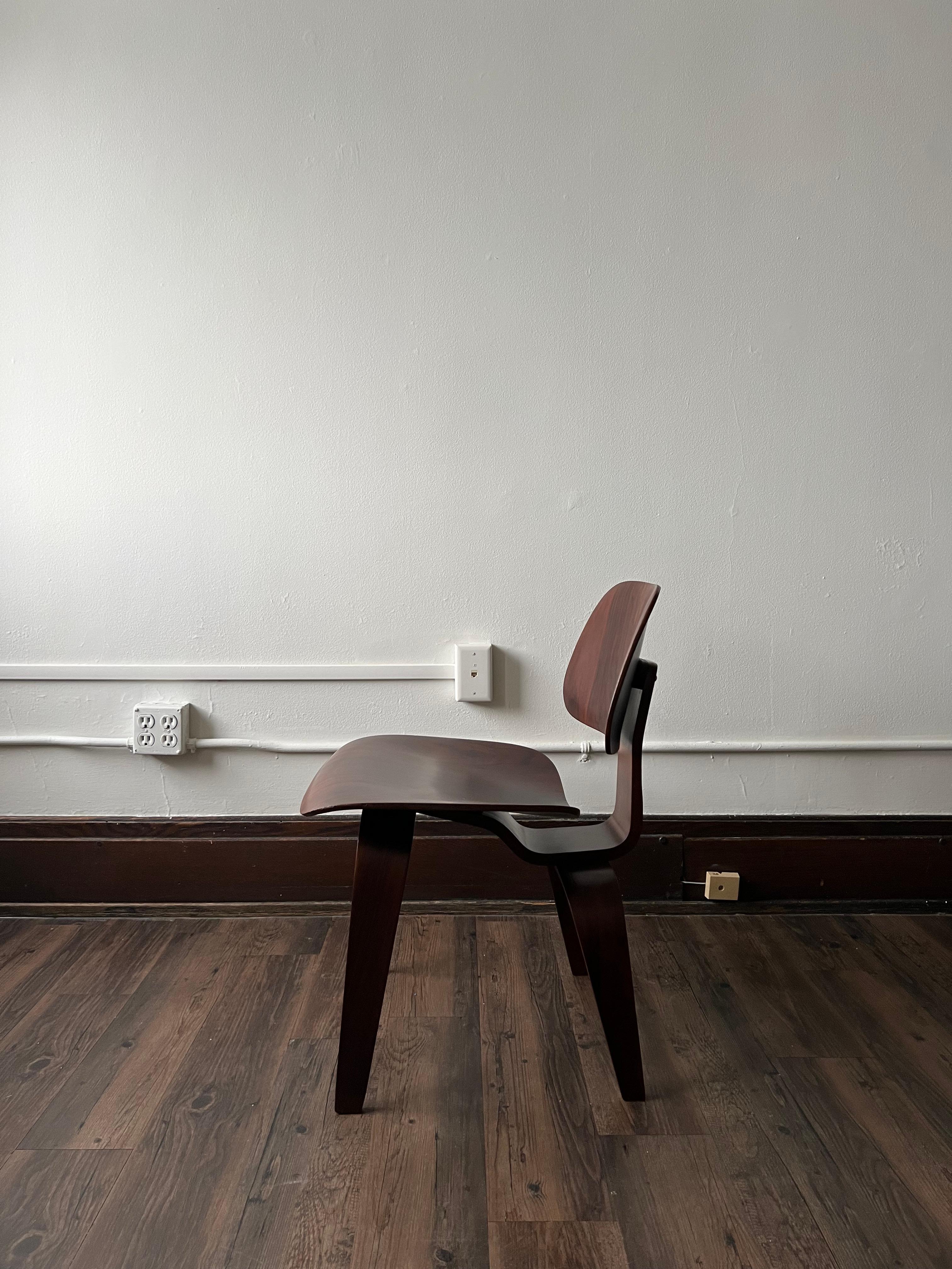 Première chaise de Charles et Ray Eames, la DCW a changé à jamais le modernisme du milieu du siècle. Cet exemplaire en bois de rose porte le label peu courant Herman Miller/ Evans Products.
