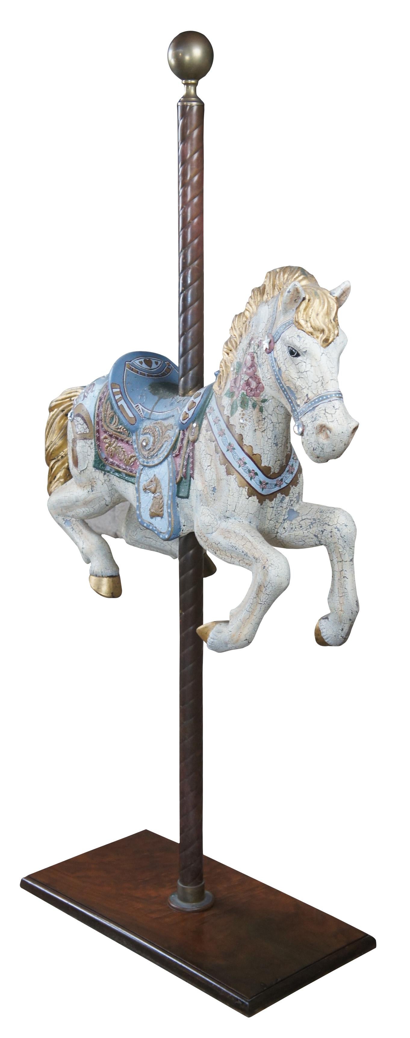 Vintage blow mold carousel horse, circa 1940s. Beautifully hand painted on a brass twisted pole over a walnut burled base. The horse is white with a crackled finish and features a blue harness and saddle with golden trim. The body is painted with