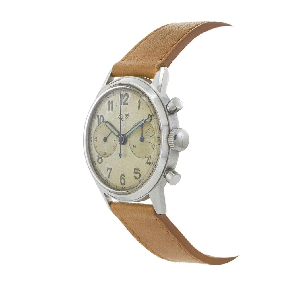 Dieser seltene und begehrte Vintage-Chronograph von 1943, die Heuer Ref. 2924 zeichnet sich durch sein übergroßes 37-mm-Edelstahlgehäuse aus, das für die damalige Zeit als groß gilt und heute sehr begehrt ist. Das silberne Zifferblatt hat im Laufe
