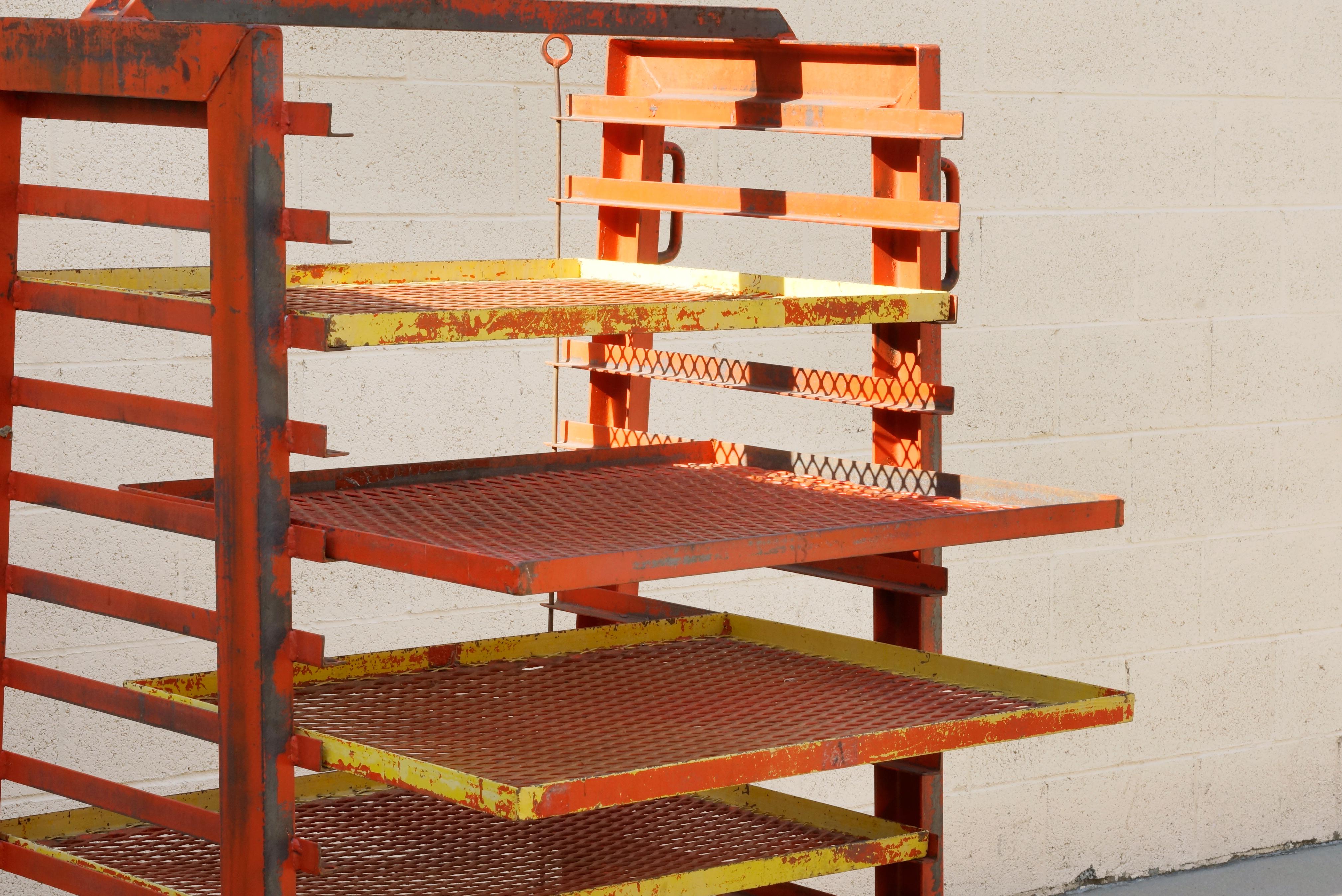 1940s vintage industrial storage rack with expanded metal shelves. This heavy duty piece is unlike any other we have seen from this era. Original purpose unclear; it may have been a mobile drying rack. Features heavy duty casters, built-in handles