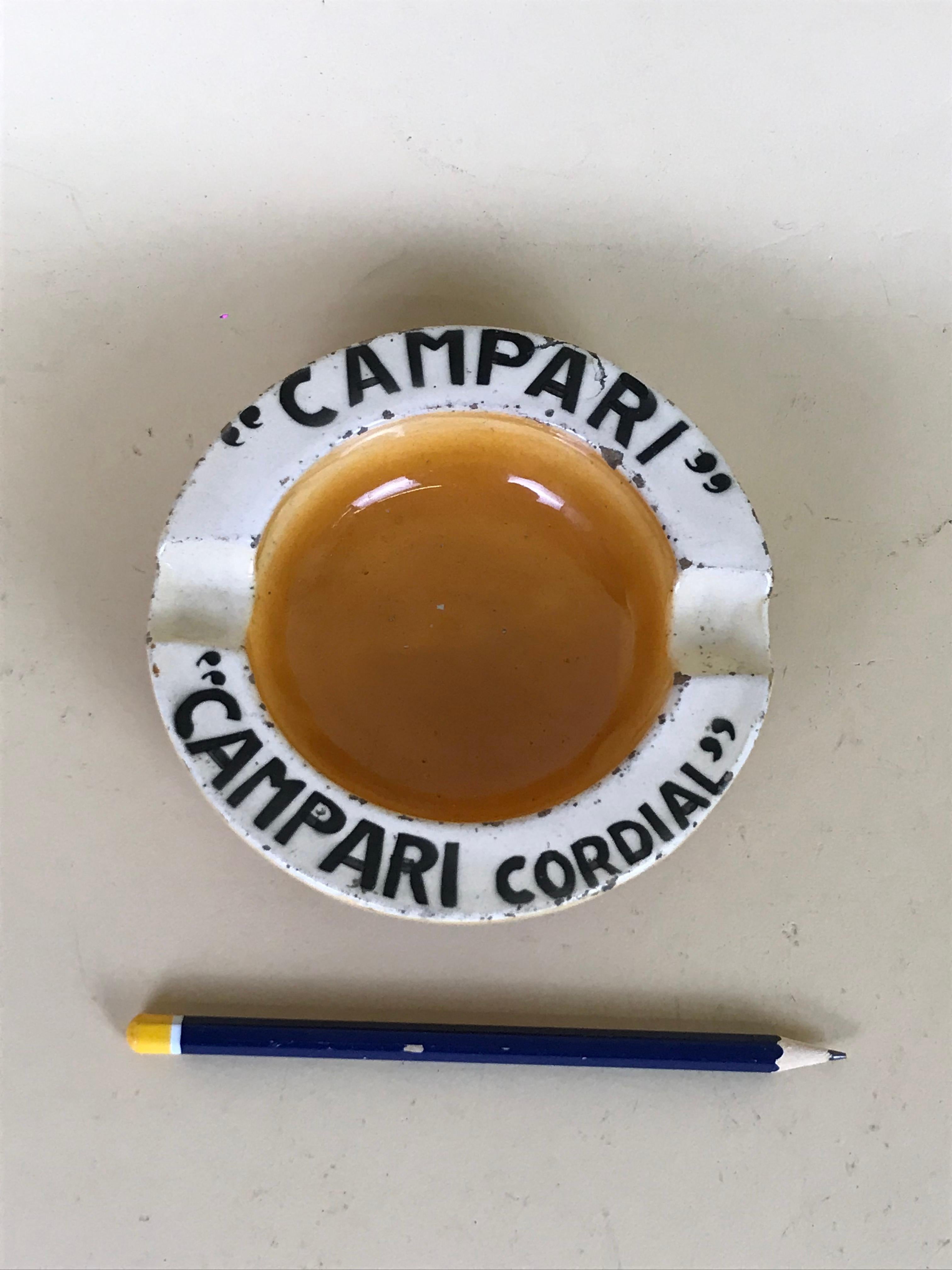 Vintage rare Campari Cordial advertising ashtray in yellow-brown and white ceramic made in Italy in 1940s.

On the top border 