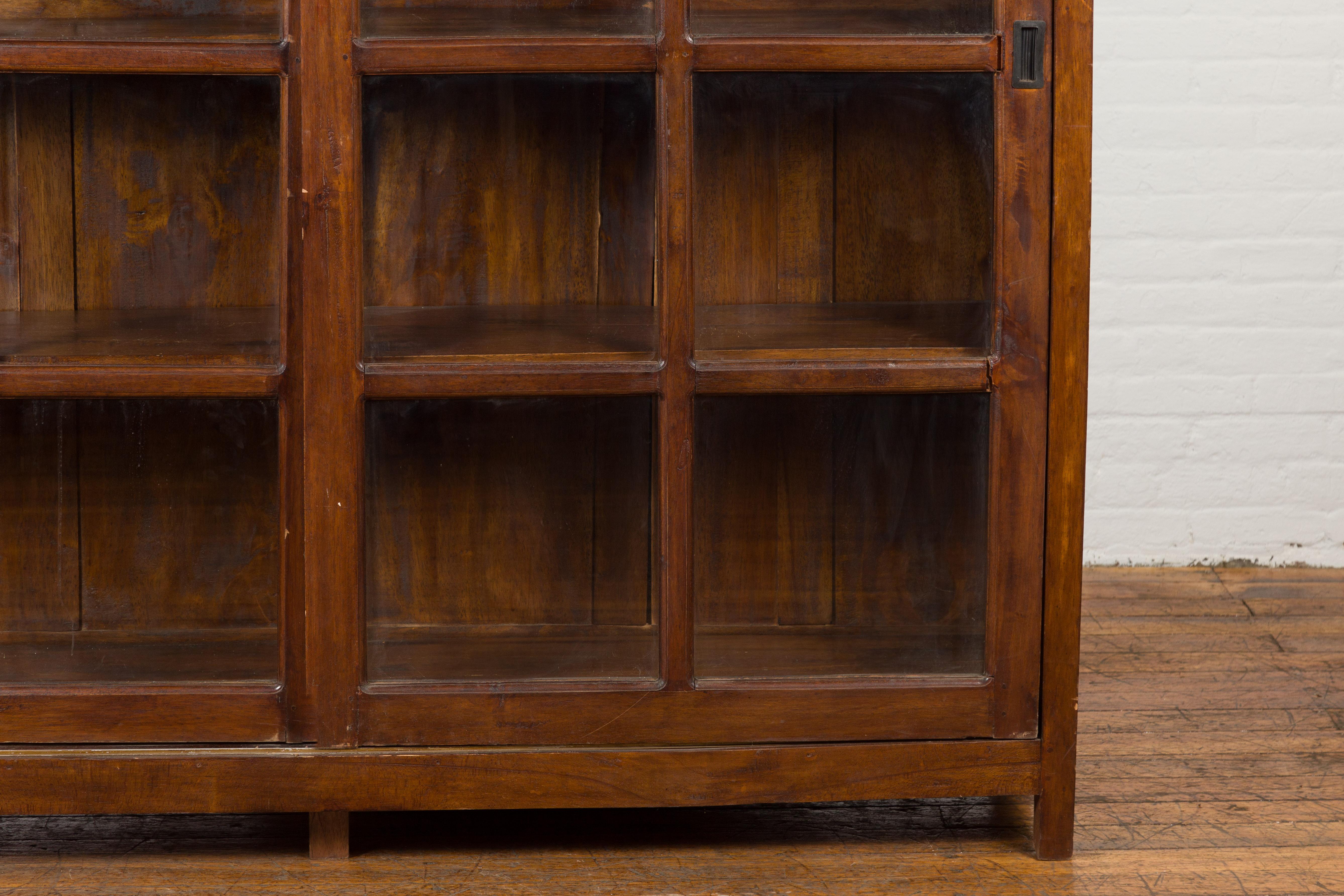 1940s Vintage Javanese Brown Wood Bookcase with Sliding Paneled Glass Doors In Good Condition For Sale In Yonkers, NY