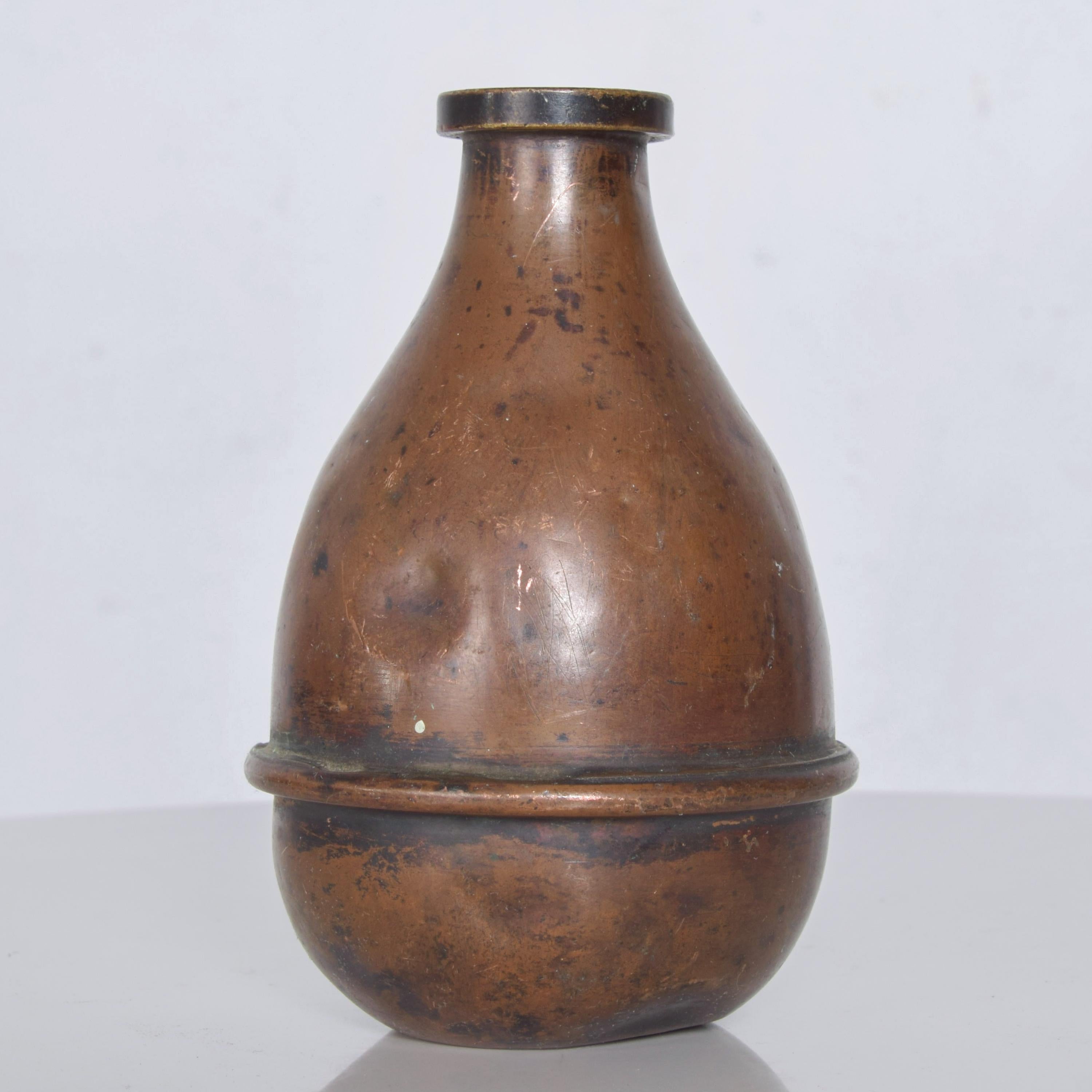 Vintage Industrial patinated copper aged bottle jug vase, USA, 1940s
Original unrestored vintage presentation. Vintage patina condition. Nicks dents and scuffs present.
No signature or label present. 
Dimensions: 5.5