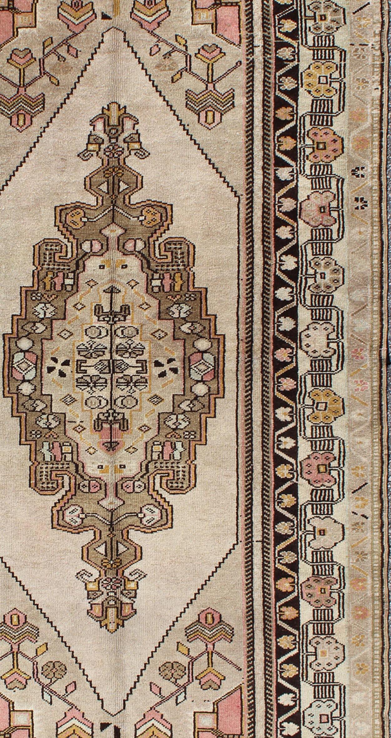 Measures: 3'9 x 7'7

This vintage Turkish Oushak carpet, (circa 1940) features a central medallion design, as well as patterns of smaller tribal-geometric elements in the four cornices and the borders. Colors include ivory, light green, black,