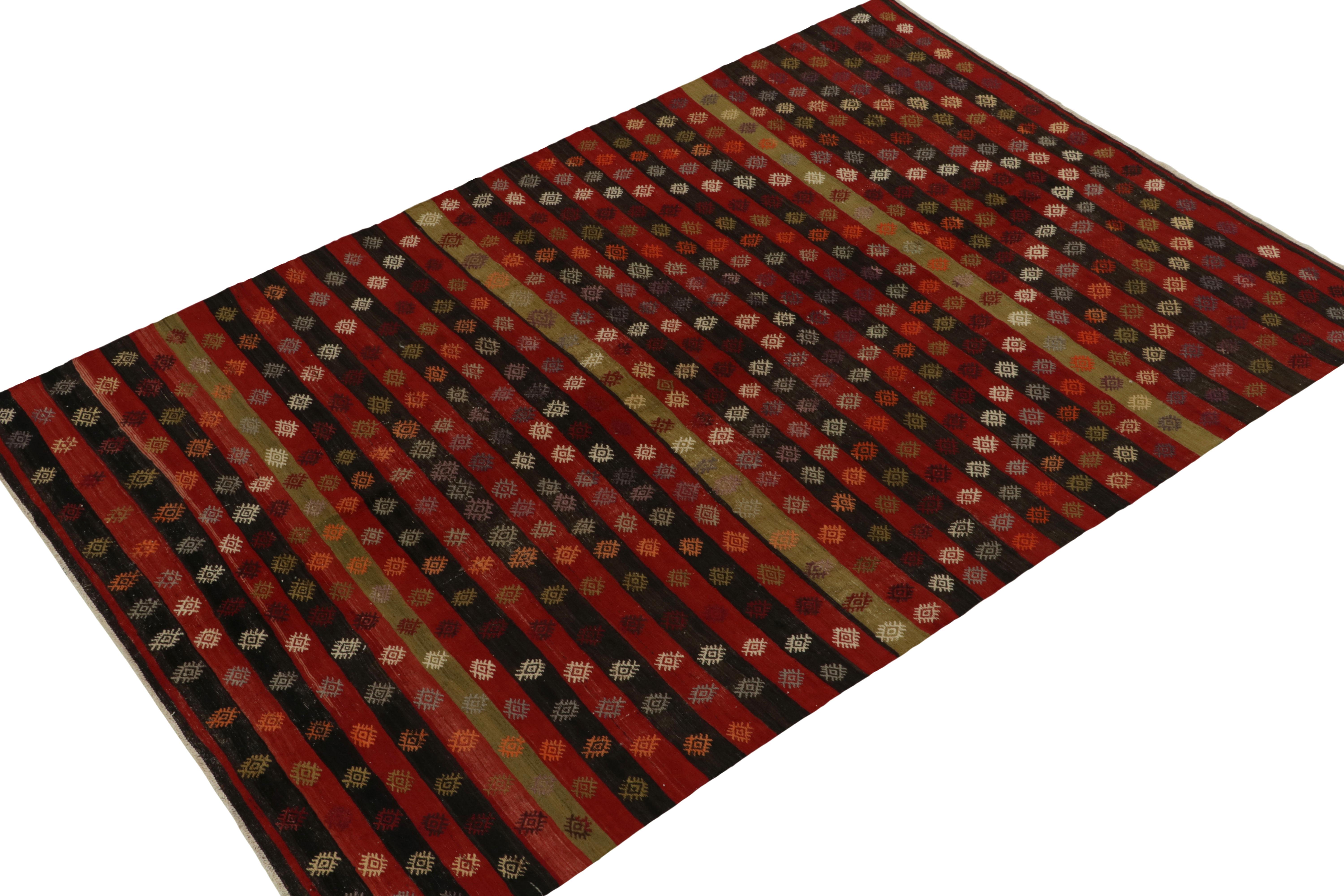 Impeccably hand woven in wool, this vintage kilim rug originates from Turkey circa 1940-1950. The 6x9 scale witnesses an outstanding marriage of embroidered patterns with subtle rarities like burdock symbols & rich tones of brown-black, red, green &