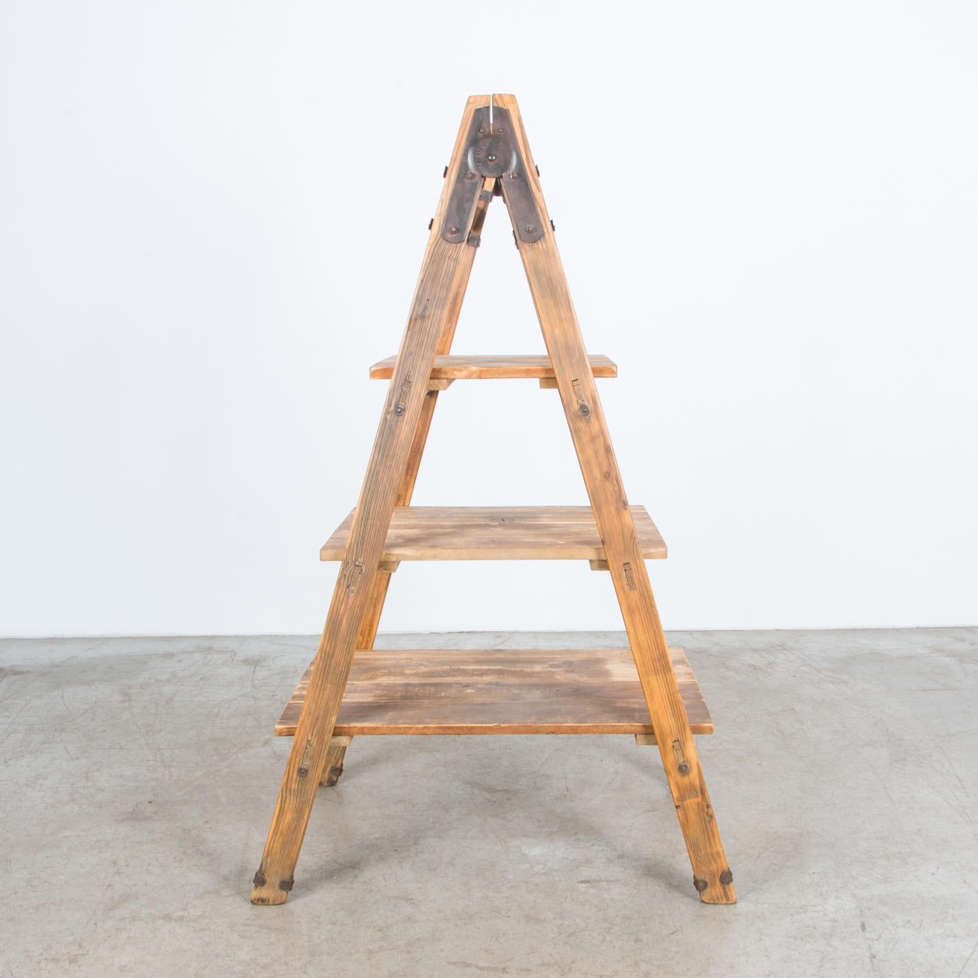 A vintage ladder from France, circa 1940. Originally used for fruit picking, this ladder is reinforced with durable iron hardware, enhancing and strengthening the rustic wooden construction. Cleaned and refreshed in our atelier, the ladder rungs