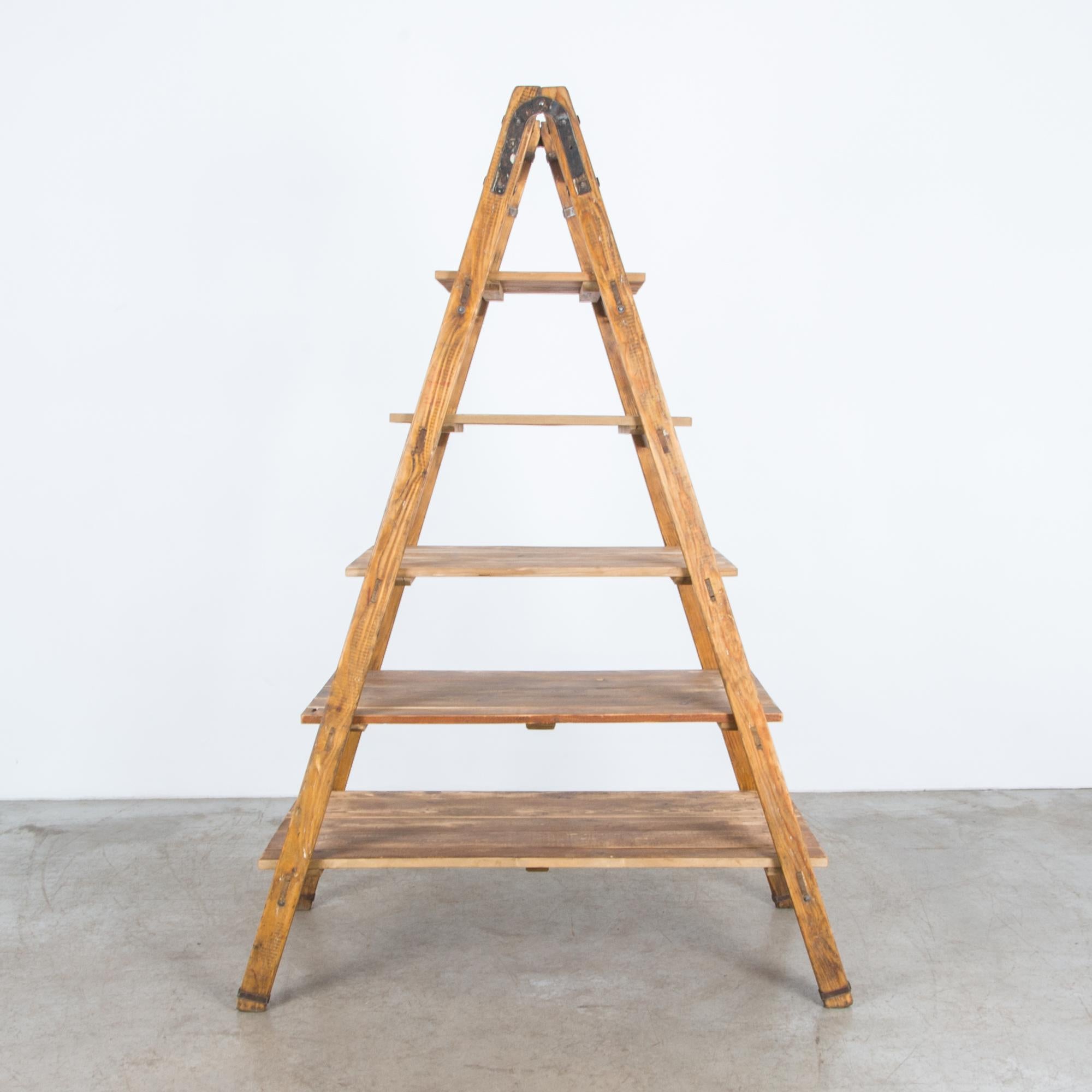 A vintage ladder from France, circa 1940. Originally used for fruit picking, this ladder is reinforced with durable iron hardware, enhancing and strengthening the rustic wooden construction. Cleaned and refreshed in our atelier, the ladder rungs