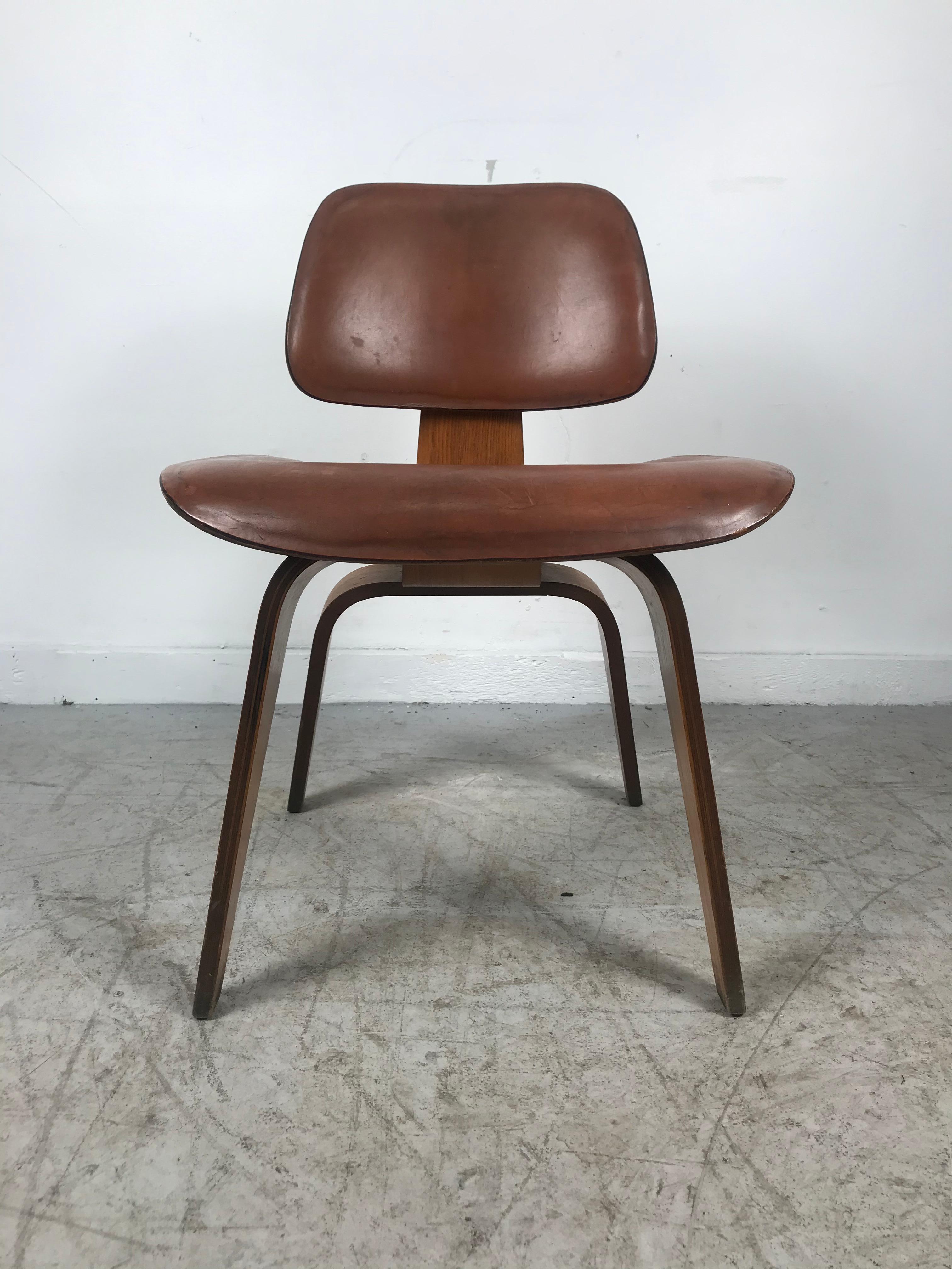 Beautiful and extremely rare DCW, dining chair wood designed by Charles & Ray Eames, art, sculpture. The chair is made of walnut with its original leather seat and back. Amazing patina. Very early production manufactured by Evans Products, late