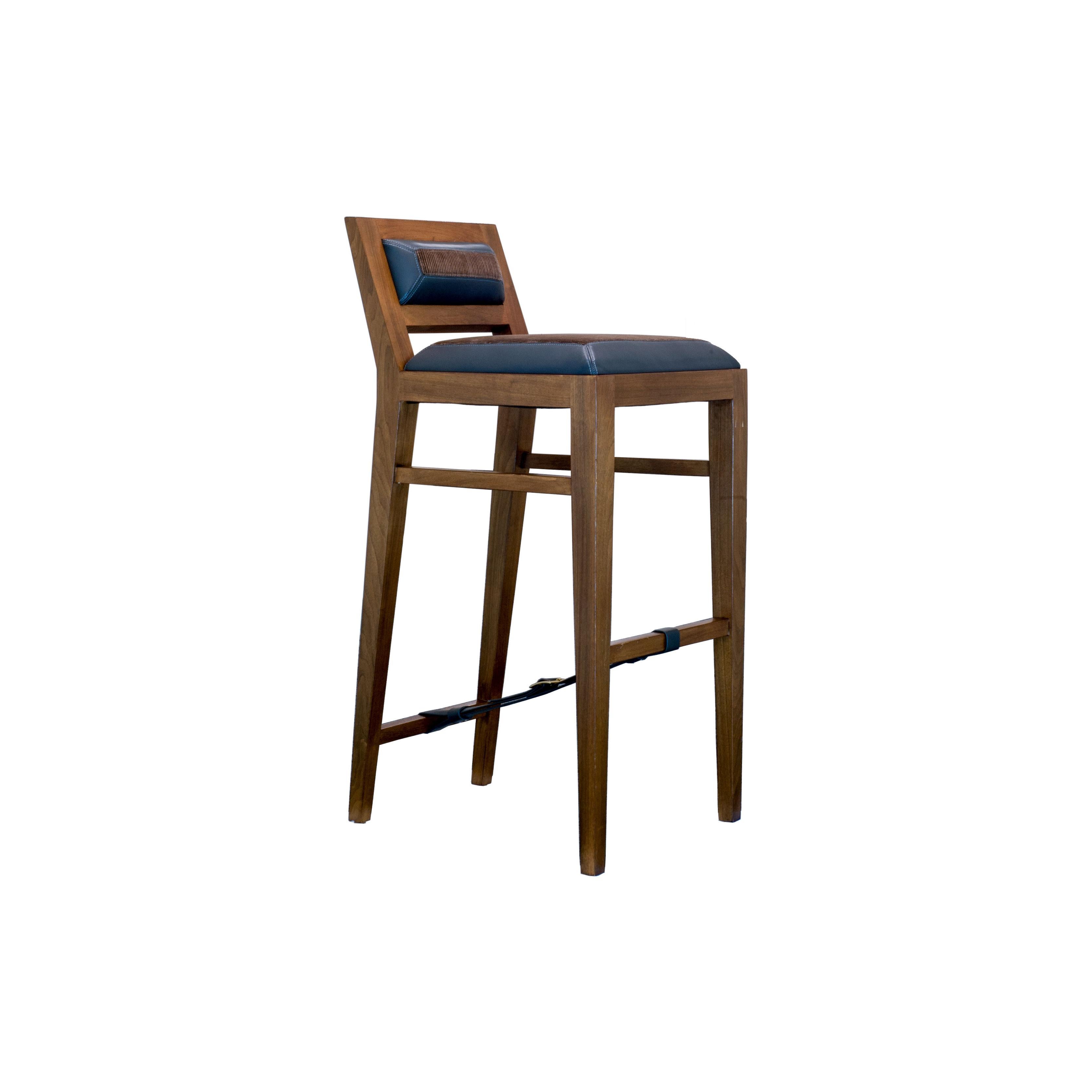 The solid walnut bar stool is hand-crafted with traditional joinery. The upholstery features a combination of leather and fabric and is an homage to 1940's French designer Jacques Adnet. Custom sizes and finishes available.