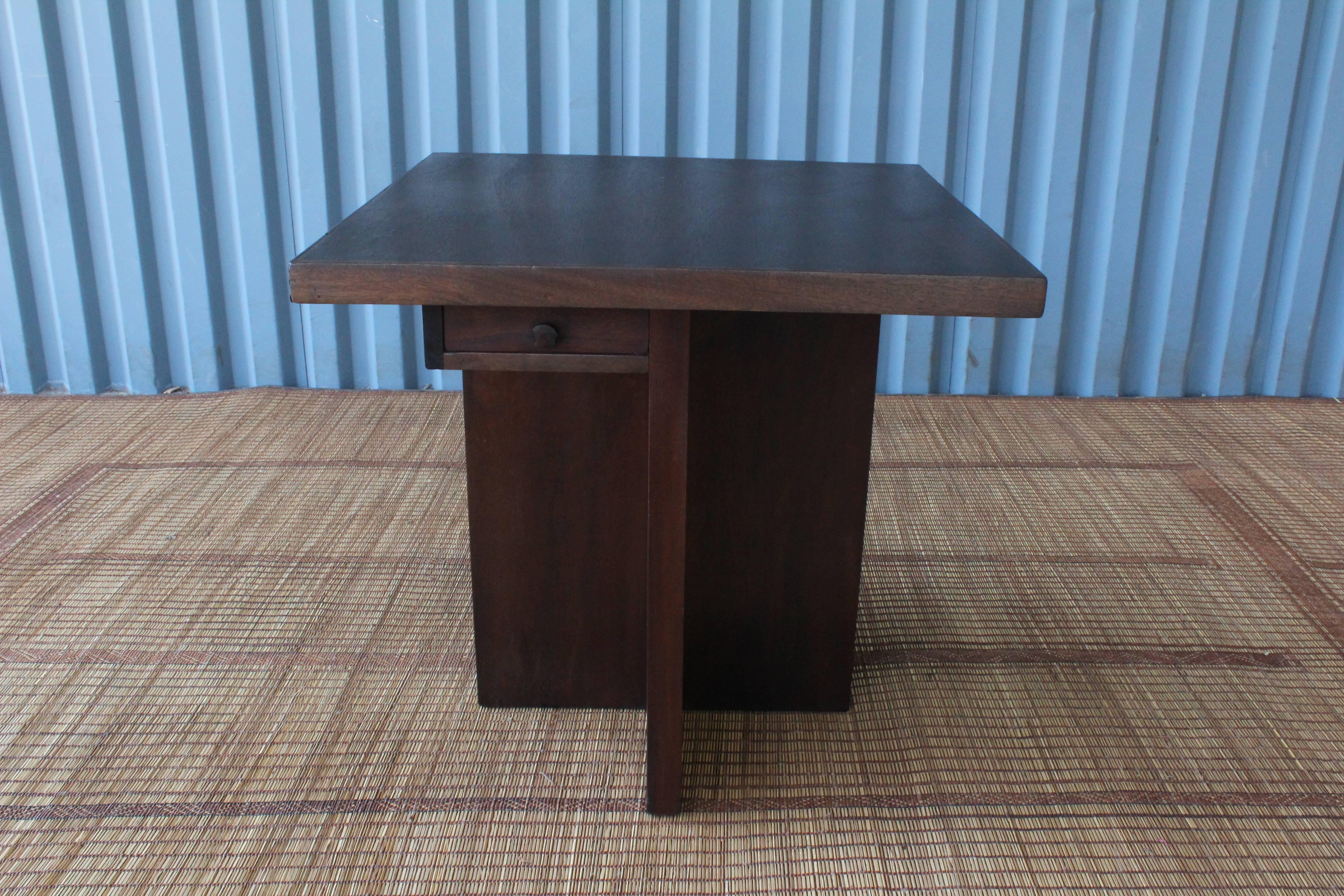 1940s walnut game table with a removable top. Features a single drawer and four pull out cup holders with brass trays. Recently refinished and fitted with a new felt top.