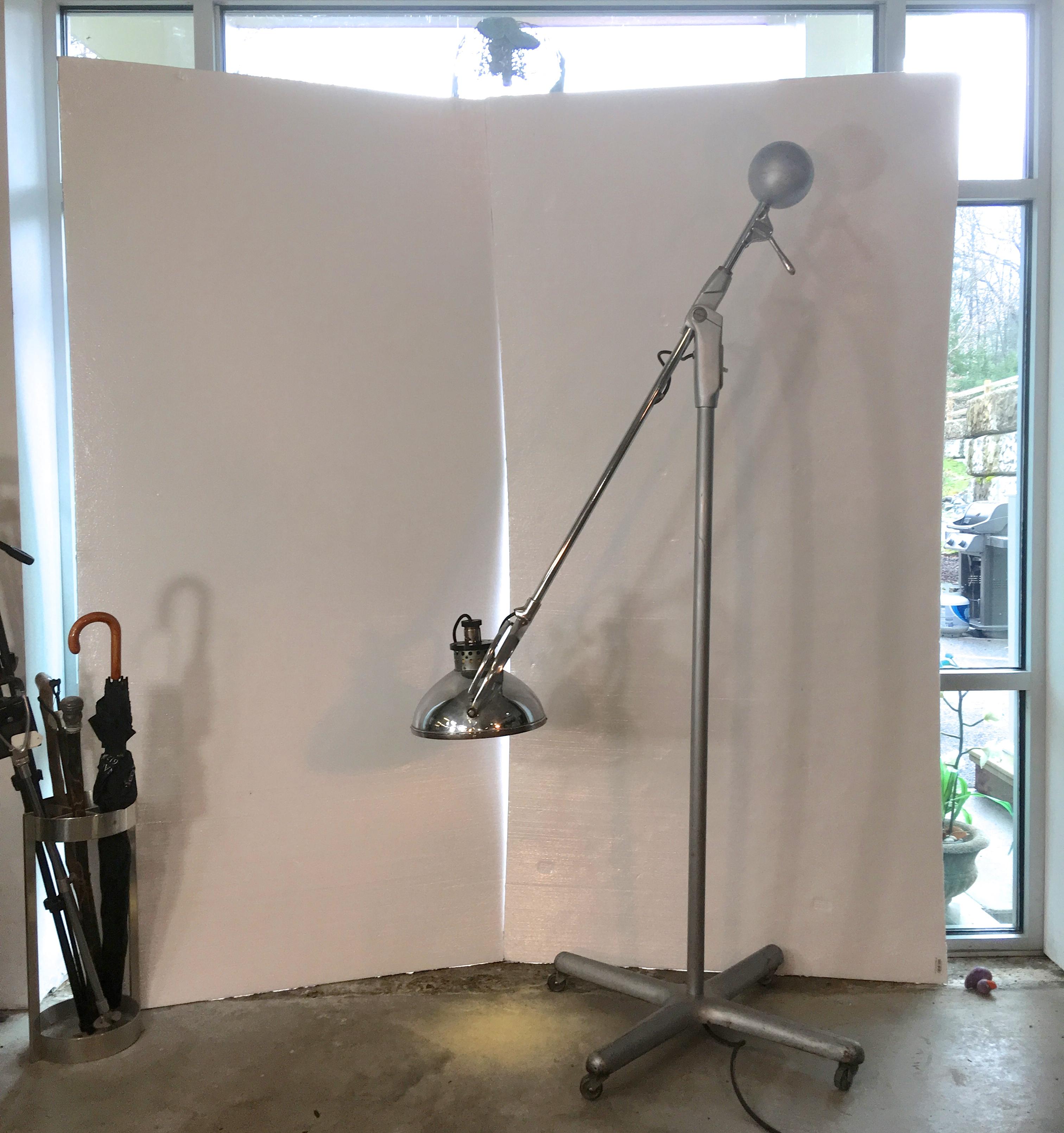 Inventor Ernest H. Greppin for Wilmot castle type 42 chrome and aluminum medical or surgical articulating counterbalance floor lamp on four star base with casters and original glass lens.