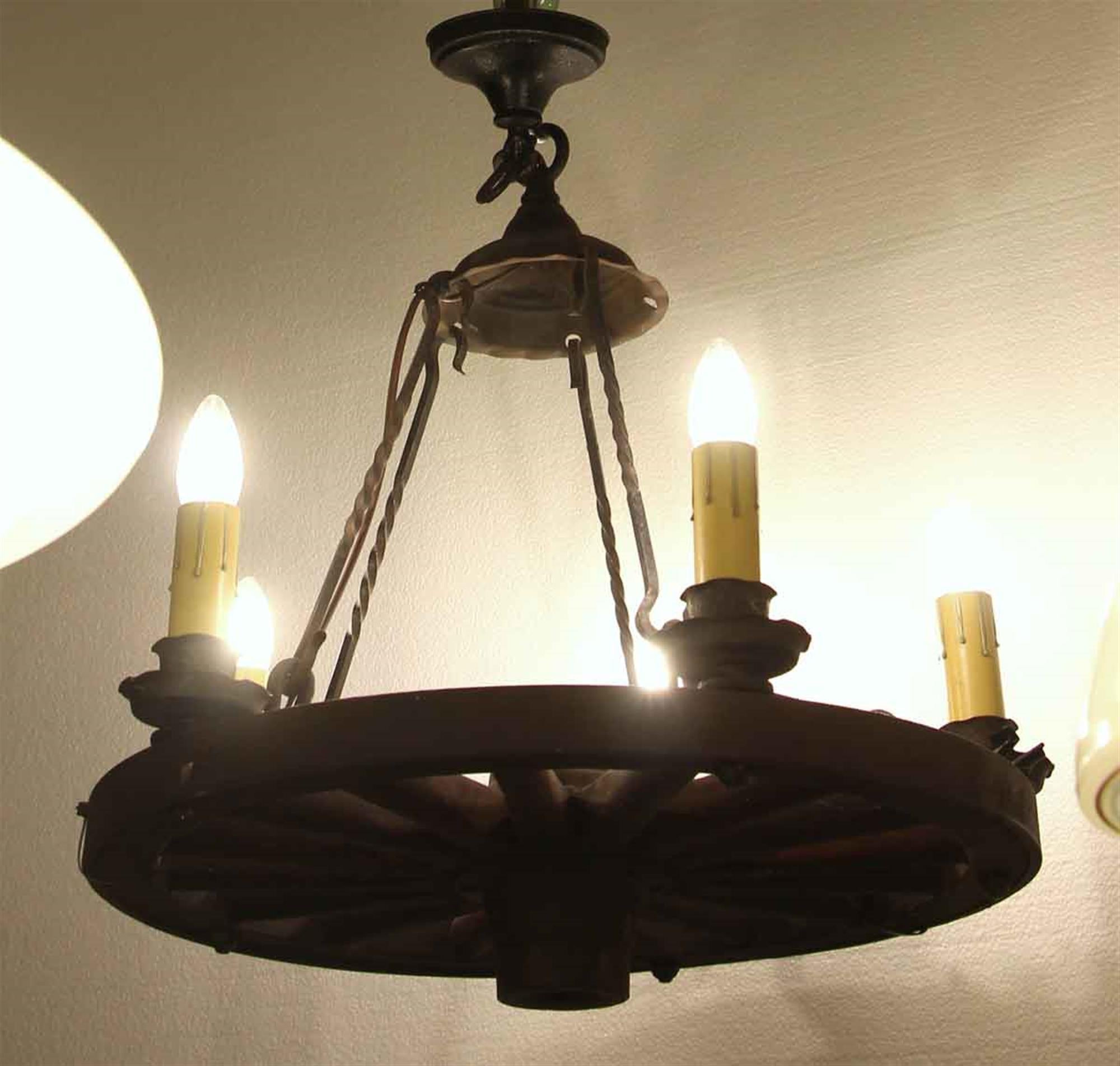 Wooden wagon wheel chandelier with wrought iron fitter and 5 candlestick arms. Small quantity available at time of posting. Please inquire. Priced each. This can be seen at our 2420 Broadway location on the upper west side in Manhattan.