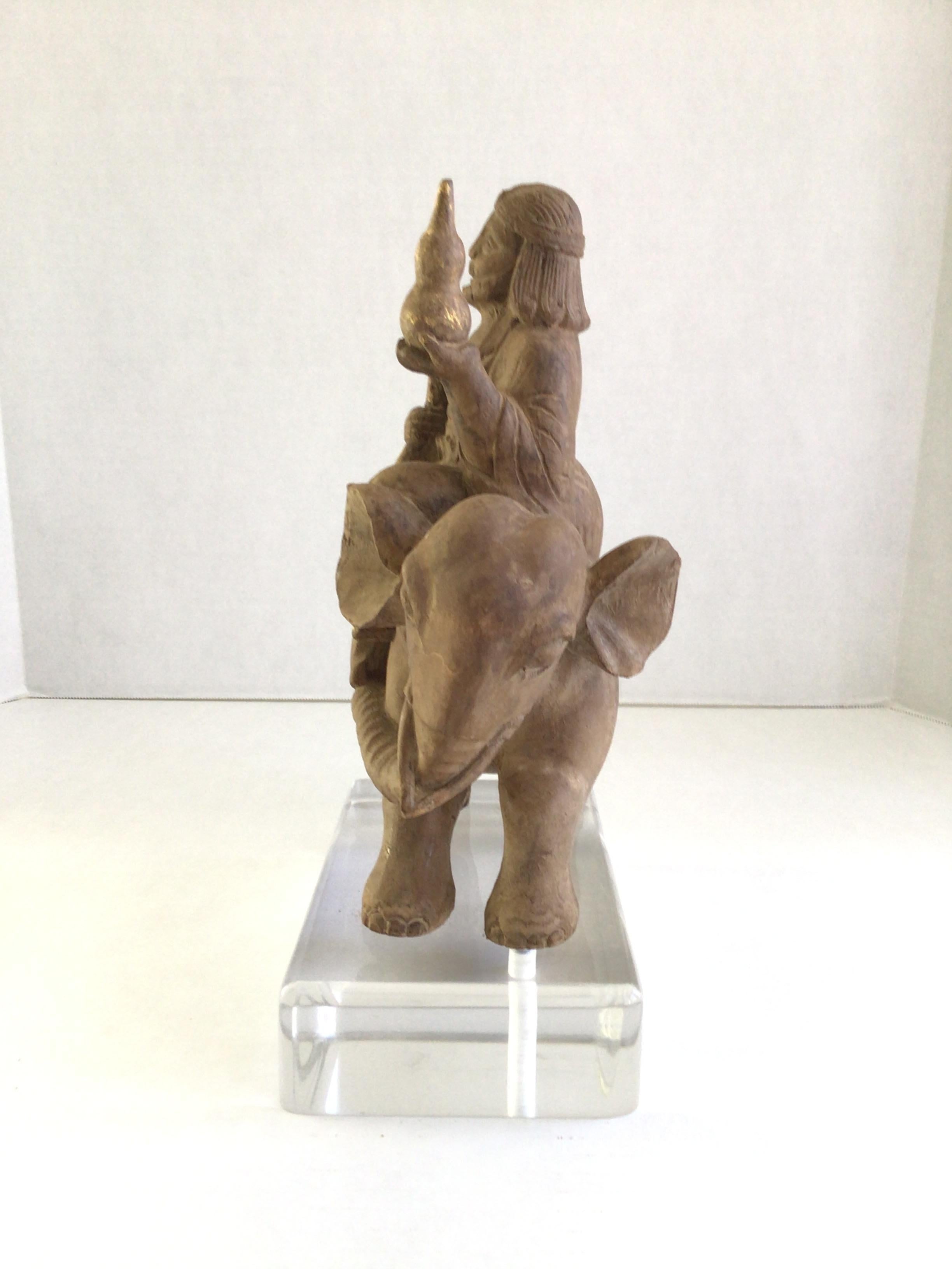 Scultura in legno degli anni '40 raffigurante un mercante che vende su un elefante
Uomo guerriero/contadino tibetano
Doratura sugli oggetti in possesso del mercante
Montato su una base in lucite 