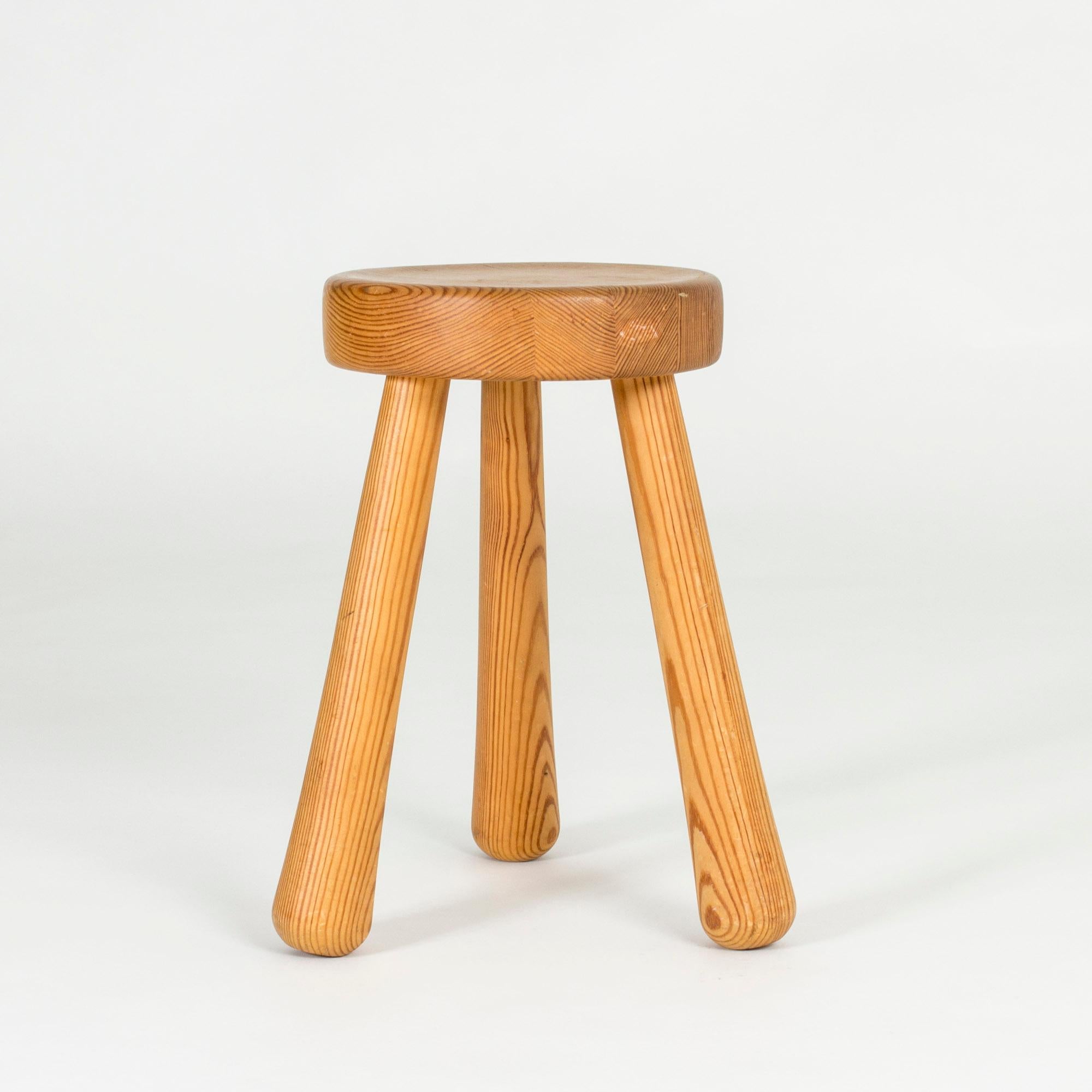 Chunky wooden stool by Ingvar Hildingsson, made from pine with beautiful woodgrain. Three elongated legs and round seat, designed in a clean, appealing shape.