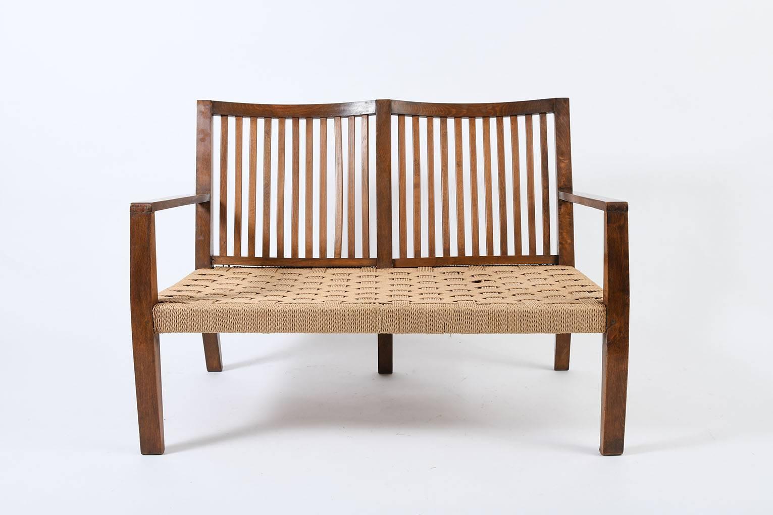 An oak and woven rope settee with a double curved back
Italy, circa 1940.