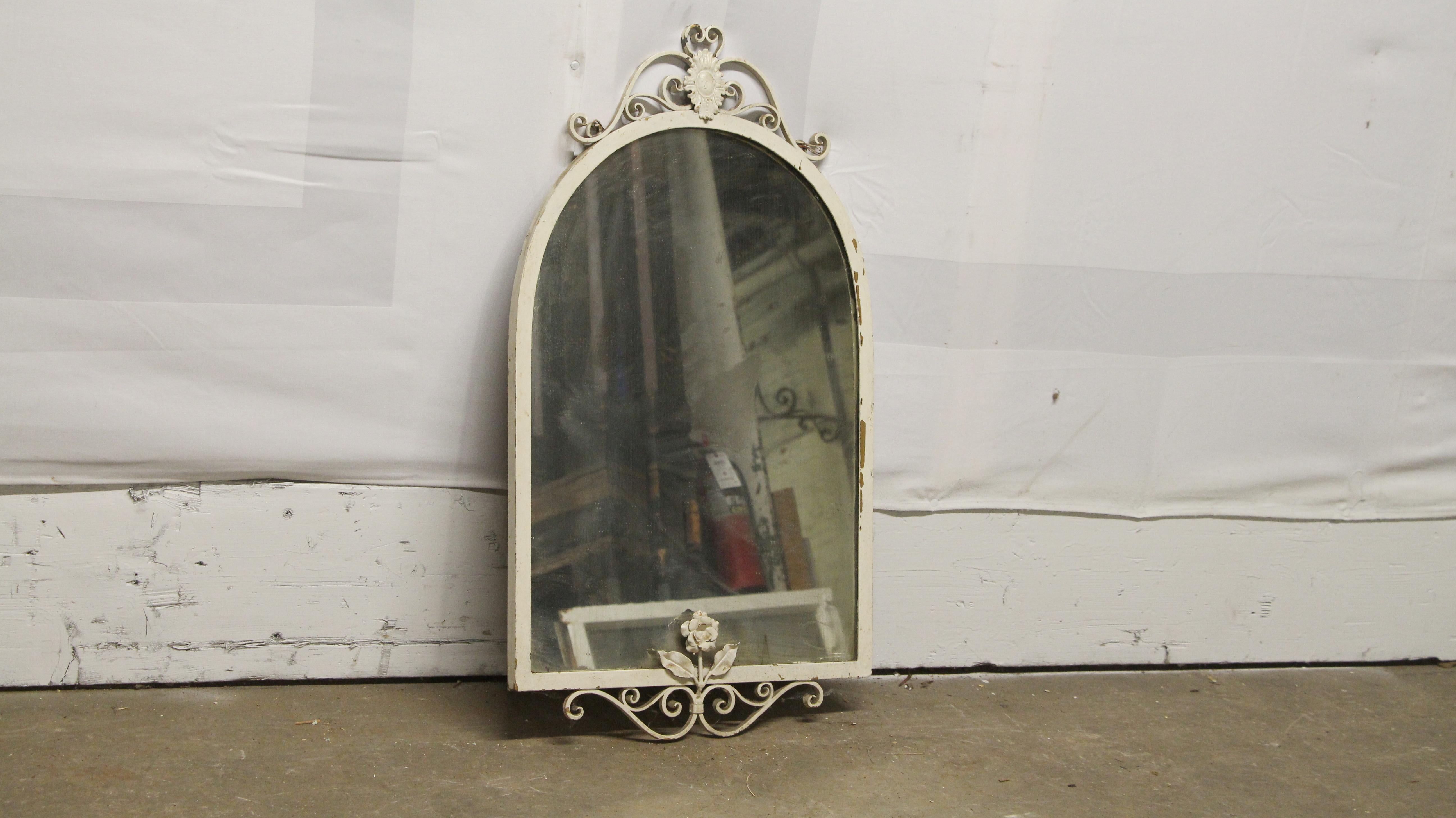 1940s shabby chic wrought iron vanity wall mirror with floral swirls detail and distressed white paint. This can be seen at our 302 Bowery location in NoHo in Manhattan.