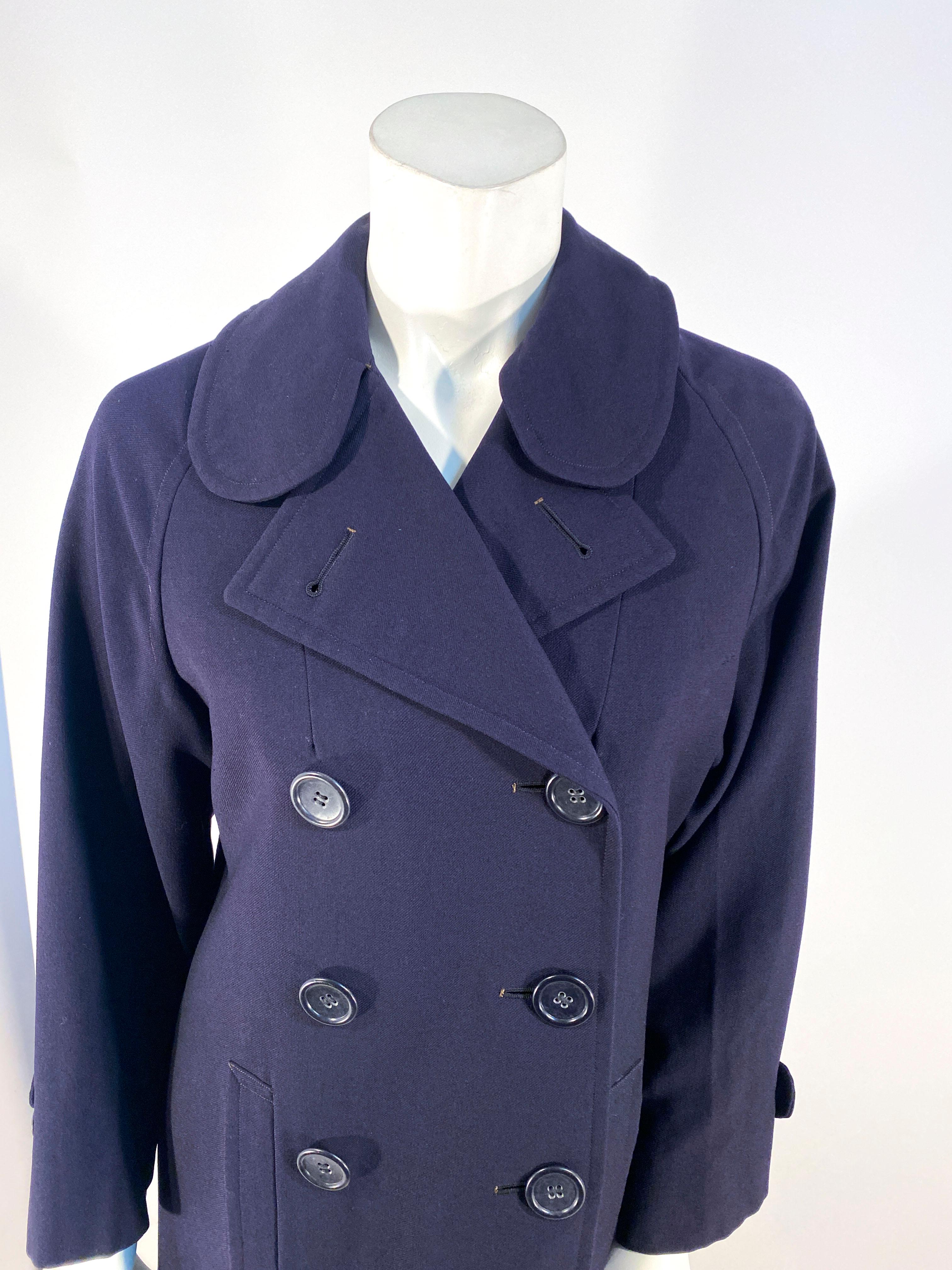 1940s WWII US Navy Woman's double breasted overcoat with two front pockets, adjustable cuffs, and a partial lining in the interior. The interior label states that this coat is a US Woman's Navy Reserve Garment. 
