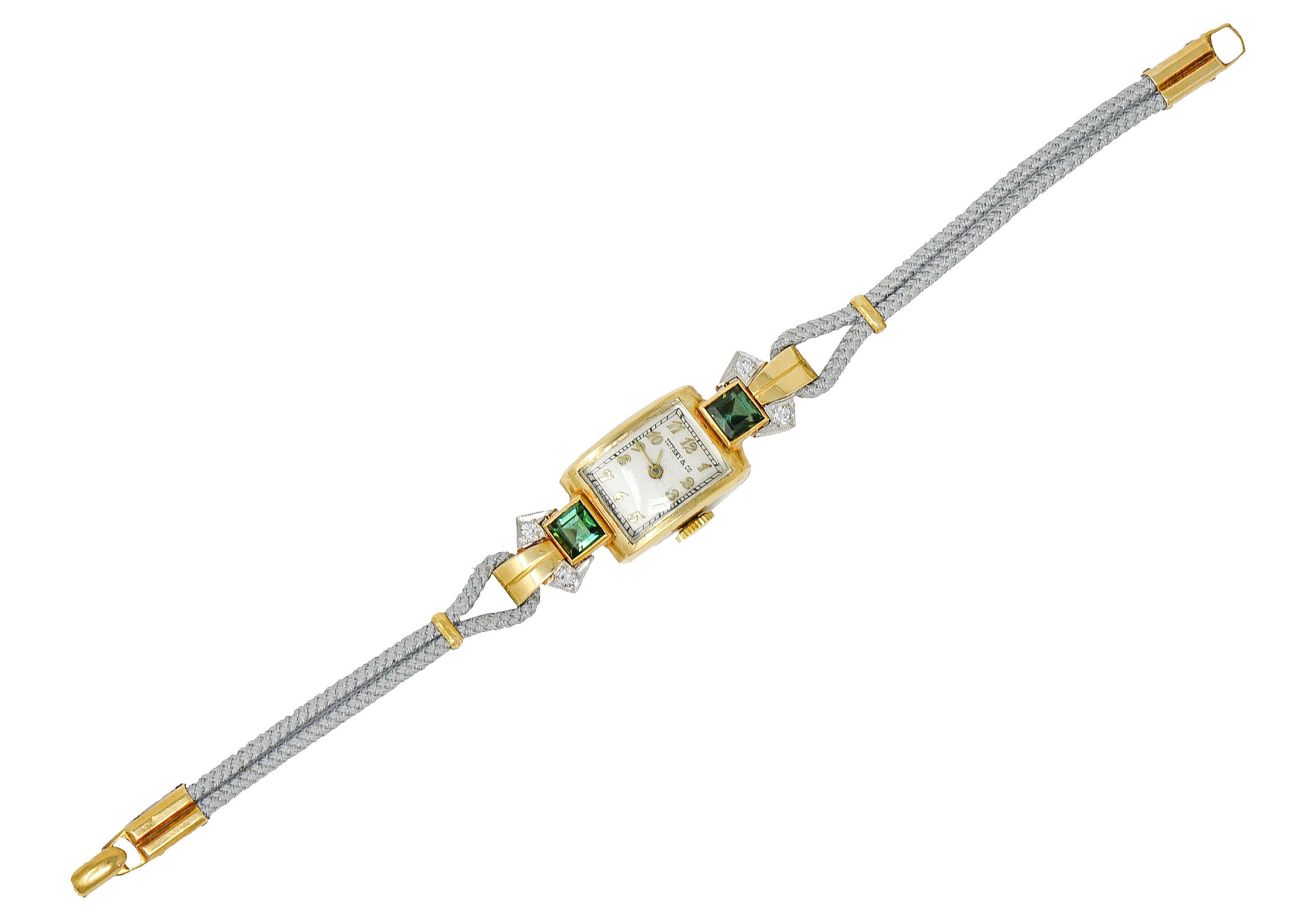 Watch bracelet centers a domed rectangular cushion case

Face is white with antique style gold numbers and dial

Flanked by two bezel set 5.0 mm square cut tourmaline - well matched and evergreen in color

With a flared shoulder design accented by