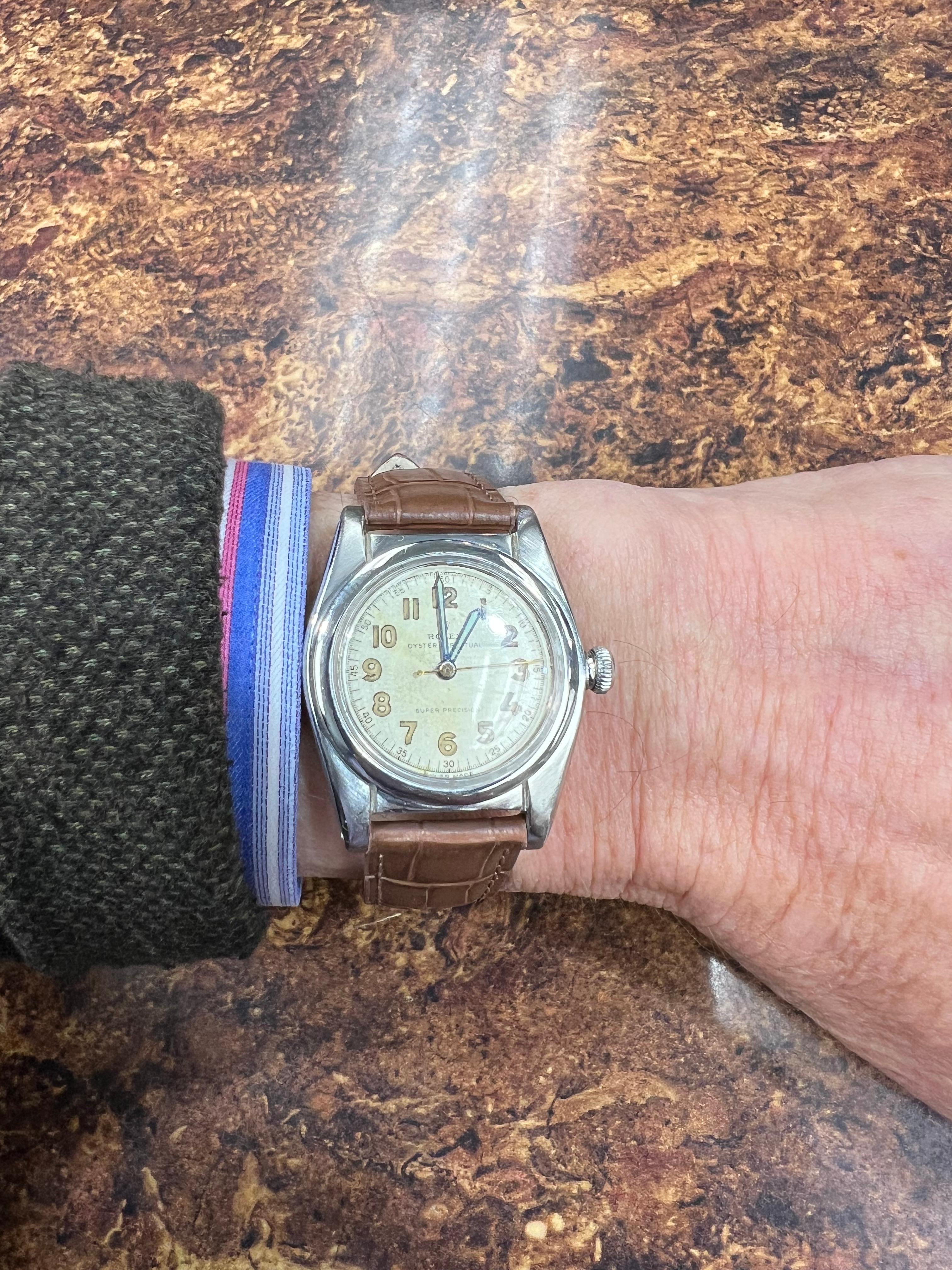1945 Montre-bracelet Rolex en acier inoxydable.

La montre-bracelet Rolex Bubbleback en acier inoxydable de 1945 est un mouvement automatique Oyster Perpetual. Le boîtier rond mesure 33 mm.  Le cadran est de couleur beige avec des index en chiffres