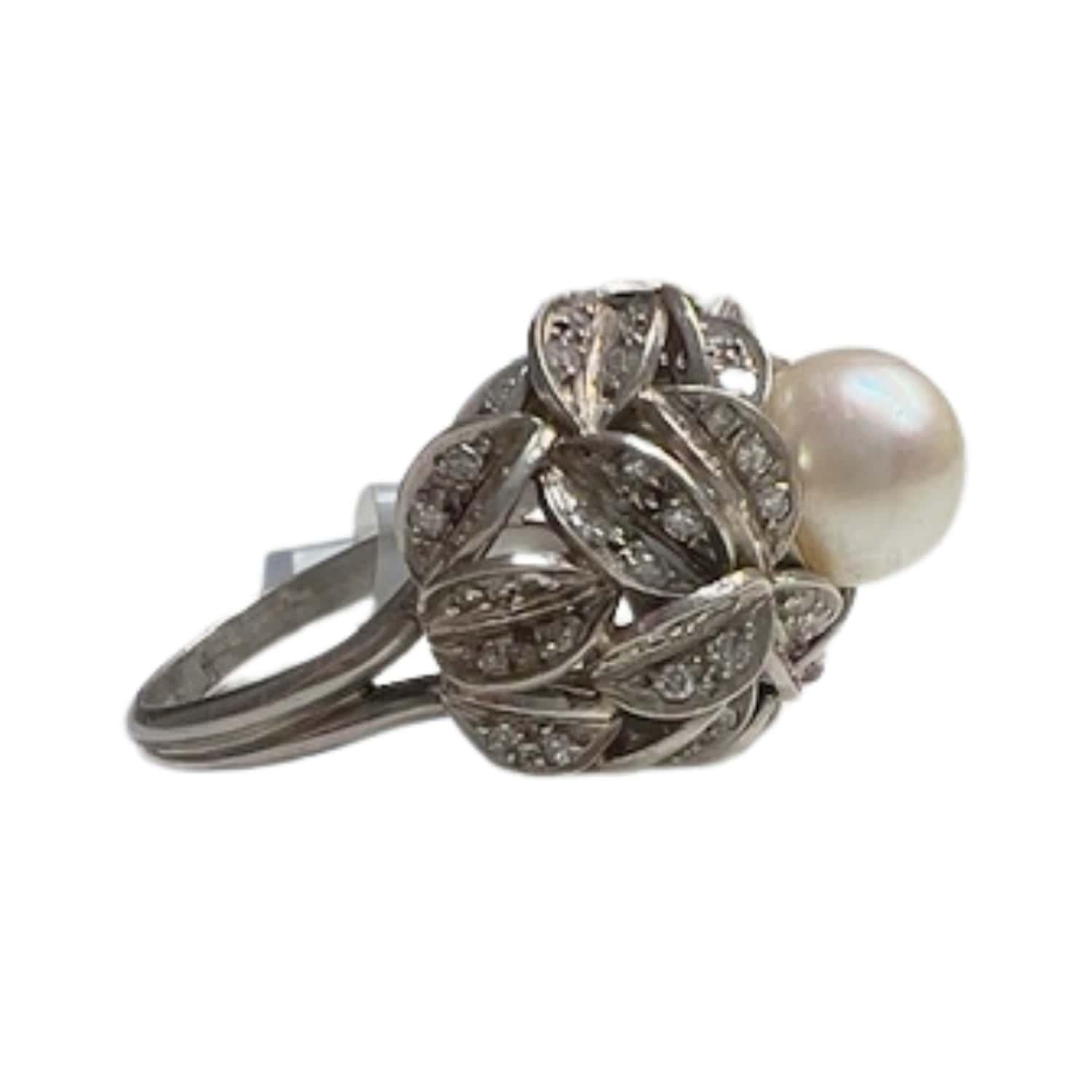 This stunning ring exudes retro charm with its design from 1945. Crafted in platinum 950 kts, it features exquisite diamonds and a lustrous pearl. The single-cut diamonds total 1.44 carats with VS-SI clarity and I-H color, adding timeless