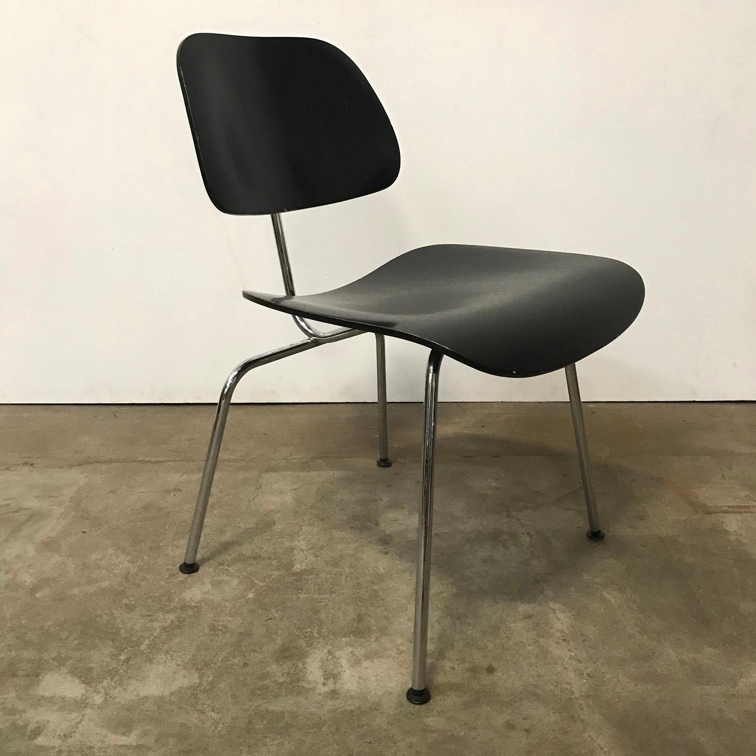 Three DCM chairs in black by Eames produced by Vitra. Priced per piece. The chairs show some traces of wear like some loss of paint, some scratches and tiny damages of the seat and back, like shown on the pictures. Also some minor spots on the