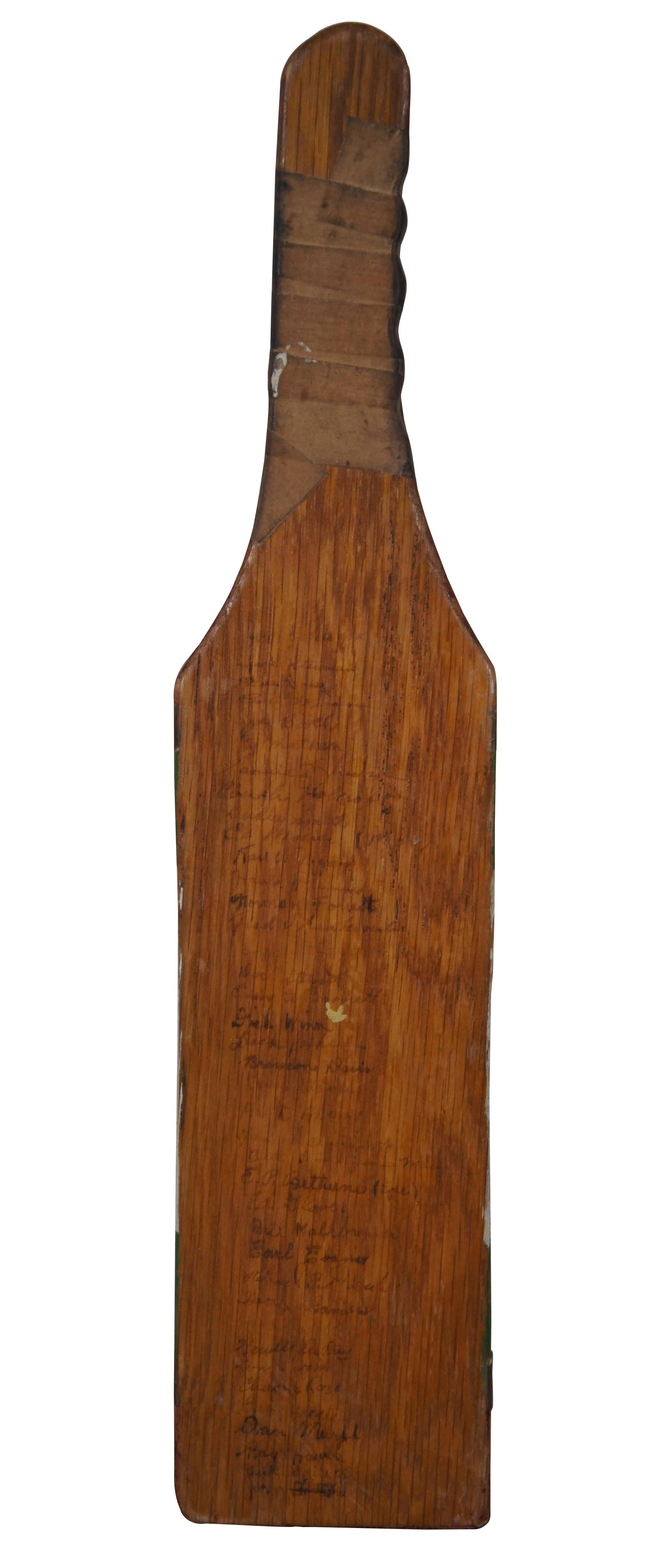 Mid 20th century Kappa Sigma fraternity wooden pledge hazing paddle, fully painted on the front in burgundy, green and white, with applied fraternity logo, taped handle and surname of original owner, (Jack) Gibson. Reverse is signed with the names