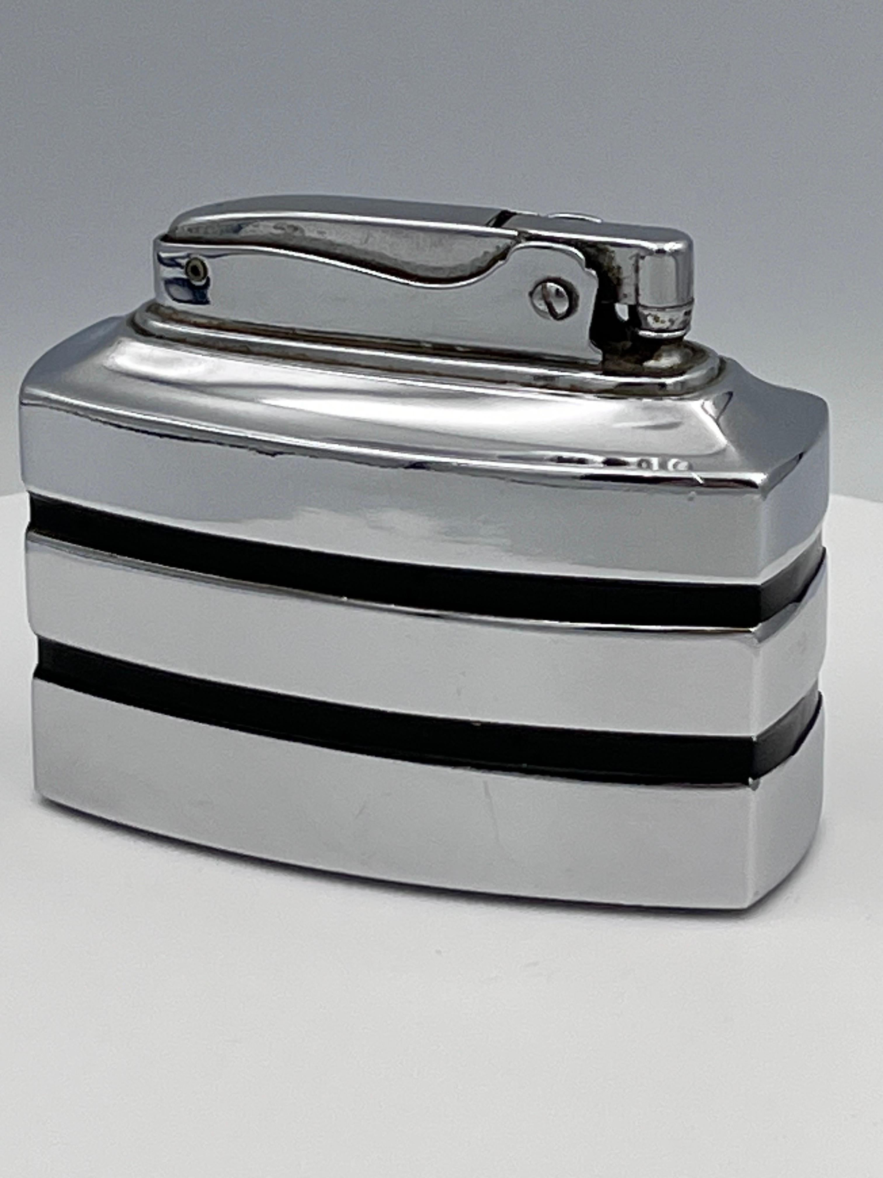 1949 Ronson “Spartan�” Streamline Table Lighter in Chrome & Black Enamel

Designed and made in the USA in 1949, this Ronson “Spartan” table lighter is a sleek slice of postwar style. Its bright chrome body is accented with bold horizontal lines of