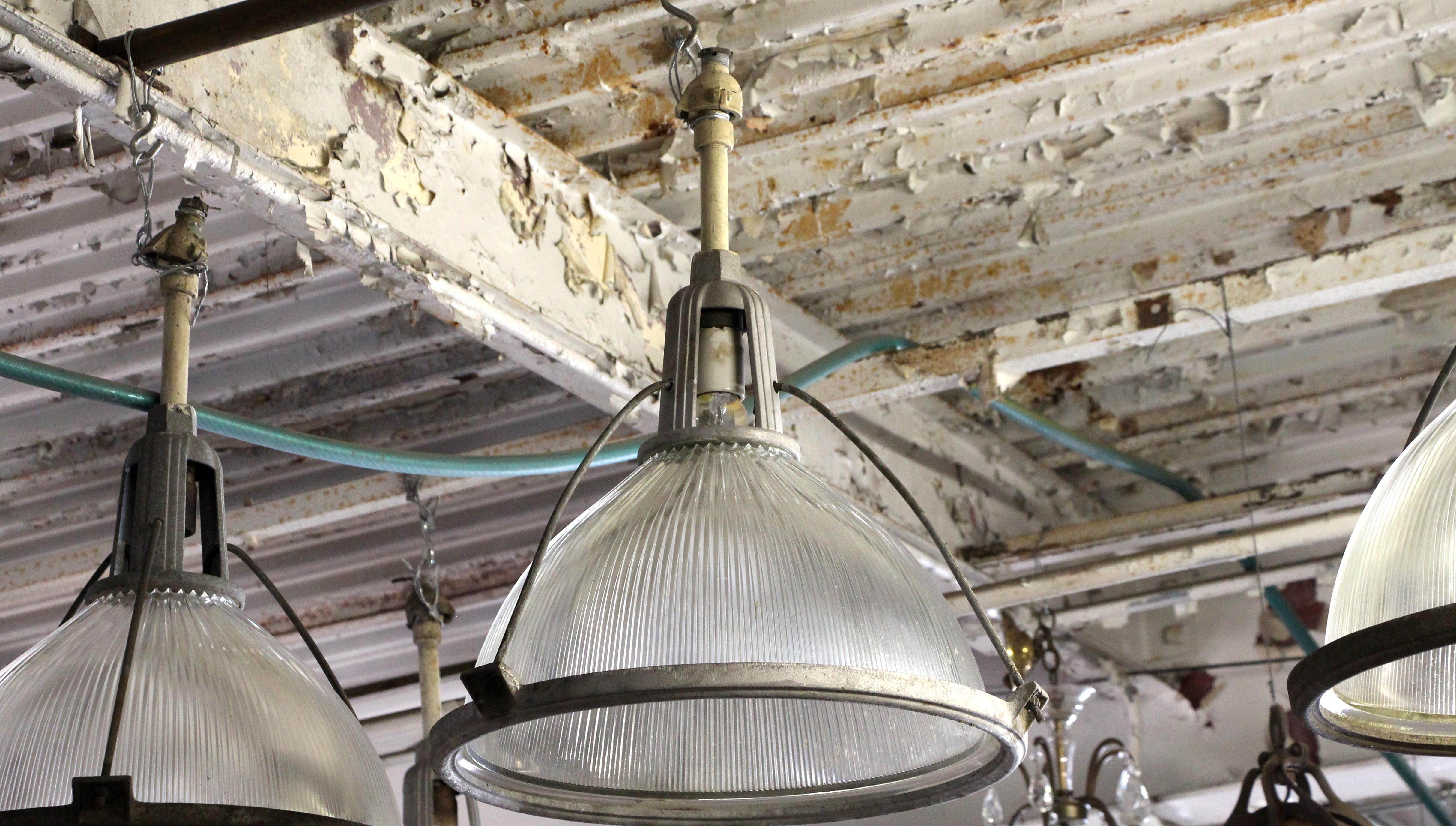 From a large industrial power plant near Shamokin, PA, this 1949 Holophane pendant fixture light is complete with the original cast aluminum Art Deco style fitter and pole. It is pictured here with the natural patina, but the fitter can also be