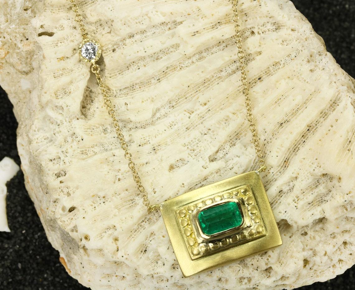 Einzigartige, handgefertigte Halskette aus Gelbgold mit natürlichem kolumbianischem Smaragd, 18 Karat. Ein göttlicher, länglicher Smaragd von 1.67 Karat sitzt in einer sicheren Lünettenfassung. Das verführerische Herzstück hat eine satte blau-grüne