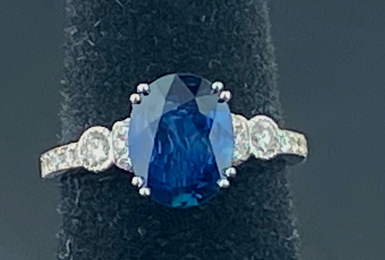 Set in 18 karat white gold is a 1.95 carat Oval Blue Sapphire with 38 Round Brilliant cut diamonds weighing 0.33 carats. Color: F-G, Clarity: SI-1.  Ring size is 4.5.