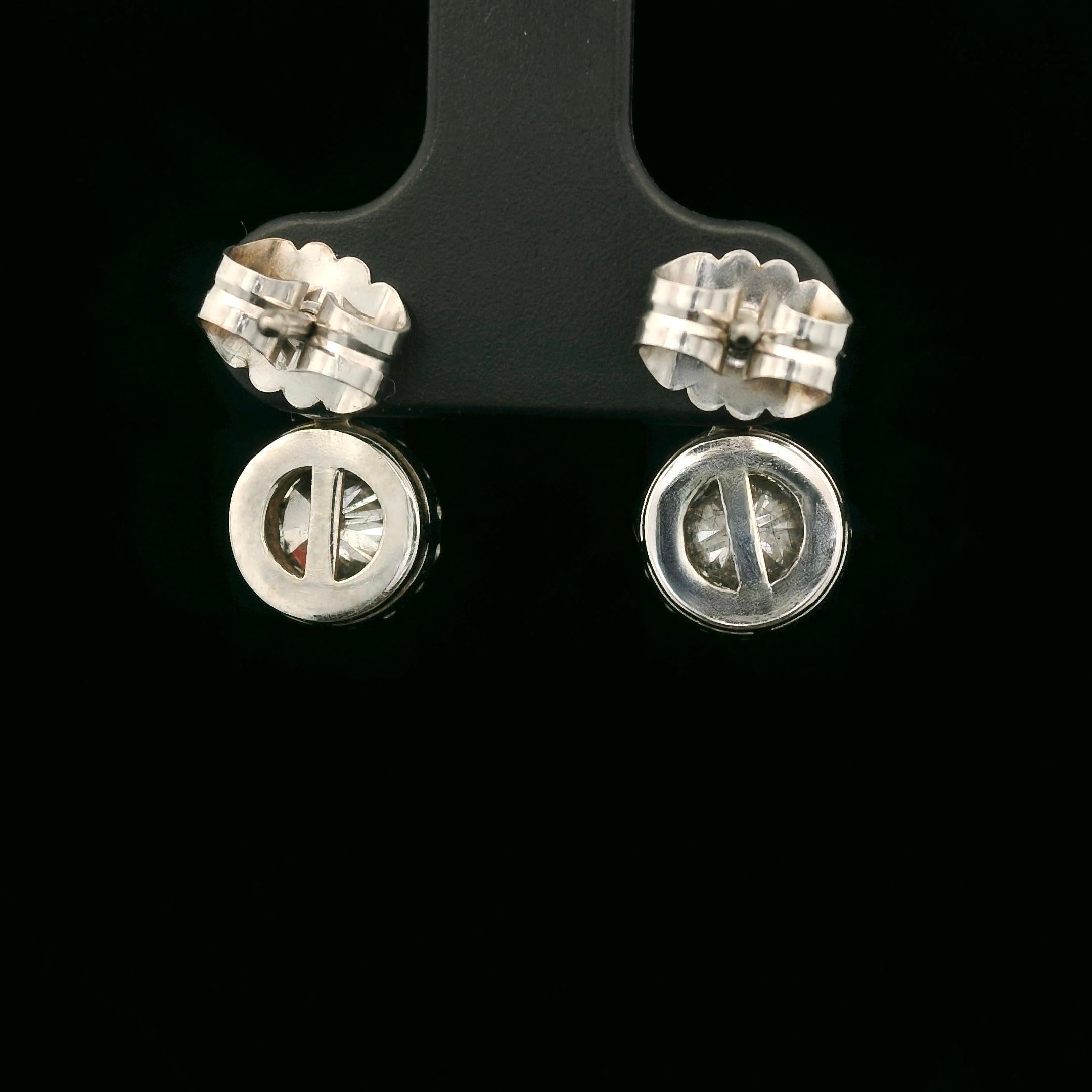 Elegantissimi orecchini moderni in oro bianco 18 carati. 

Ogni orecchino è incastonato con un piccolo diamante brillante di circa 0,22 carati e un diamante brillante di circa 0,78 carati circondato da piccoli diamanti brillanti. 
Gli orecchini sono