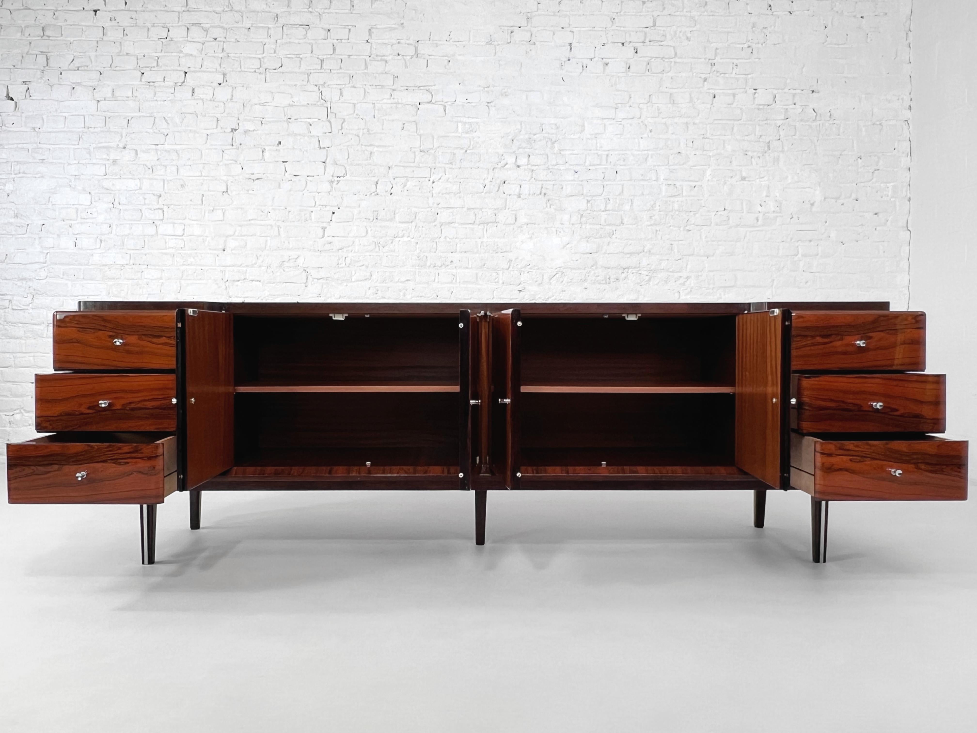 1950 -1960s Italian Design Rosewood Glossy Finishes Curved Sideboard composed of rosewood wooden structure. It features 3 large drawers each side and door panels opening on shelves storage in the middle. Glossy finish, chrome handles and outlines on