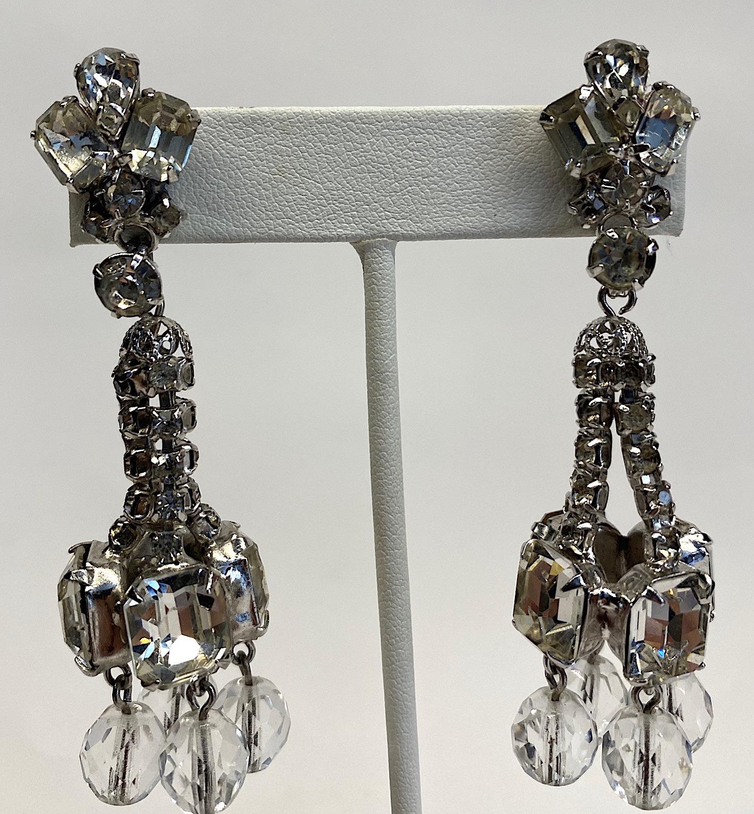 A lovely pair of late 1950s to early 1960s pendant rhinestone earrings with posts for pierced ears. Originally clip back, the previous owner has them converted to a post back. The metalwork is rhodium plate. The top of the earring is a comprised of