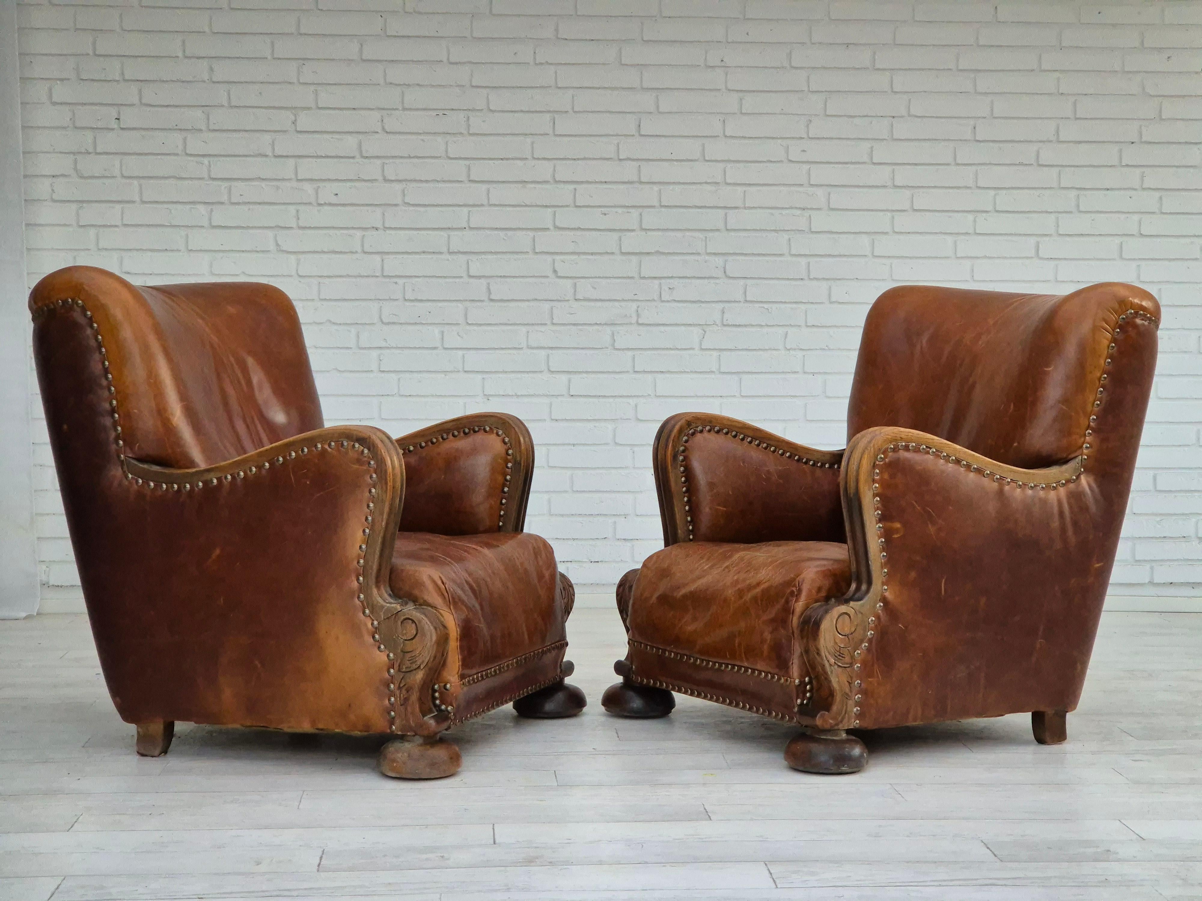 1950-60s, Danish relax armchair in good condition: no smells and no stains. Brown leather with patina, oak wood legs, and armrests. Brass springs in the seat. Manufactured by Danish furniture manufacturer in about 1950-60s.