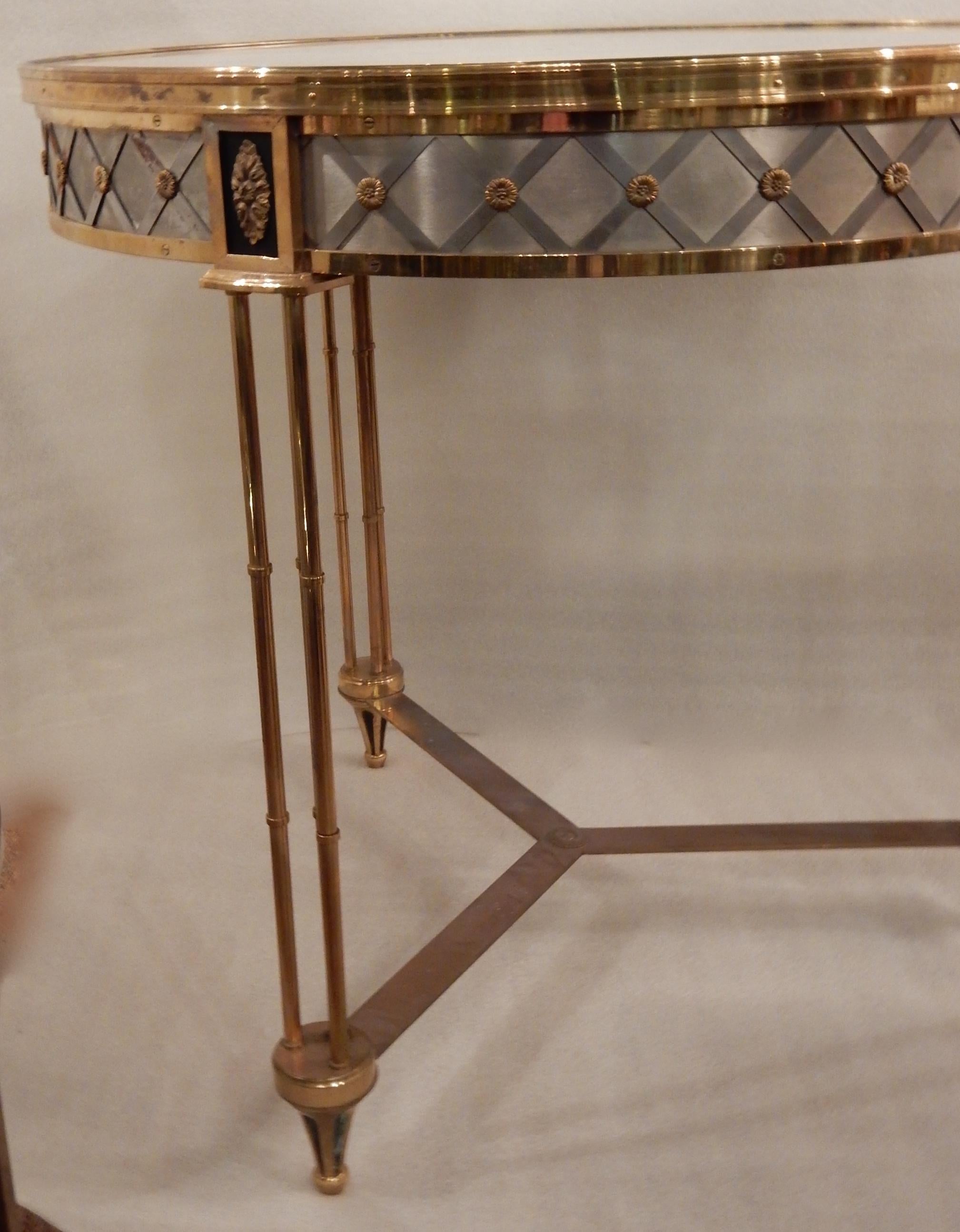 Pedestal table in gilded bronze with an upper top in white marble, supported by three feet, each made of three rods imitating bamboo which end in a spinning top foot, the feet are linked together by a spacer decorated with a central pellet. The