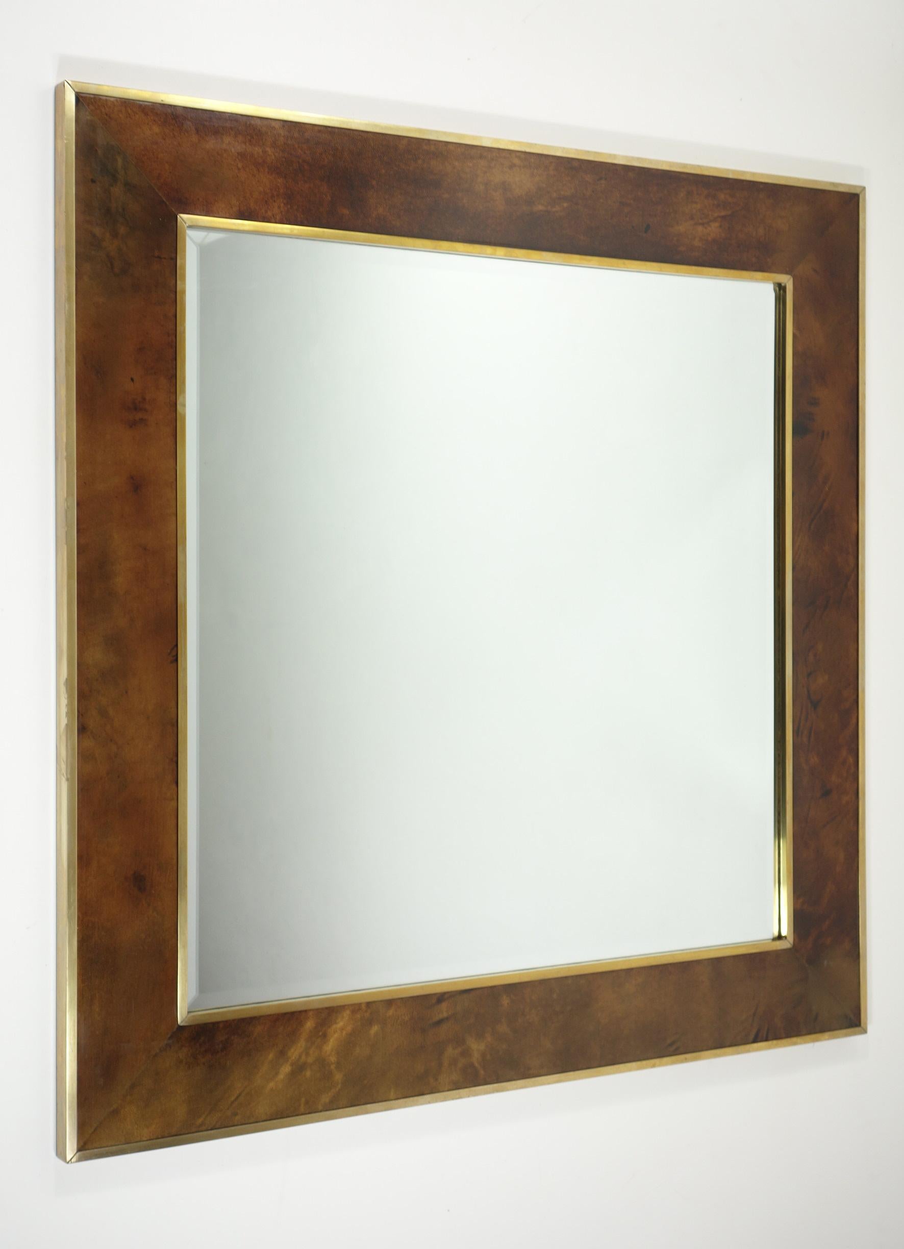 Se trata de un espejo de pared cuadrado vintage diseñado por Aldo Tura, famoso por su innovador uso de materiales lujosos y su inconfundible estilo de mediados de siglo. Con un marco de rico pergamino marrón con sutiles variaciones tonales, el